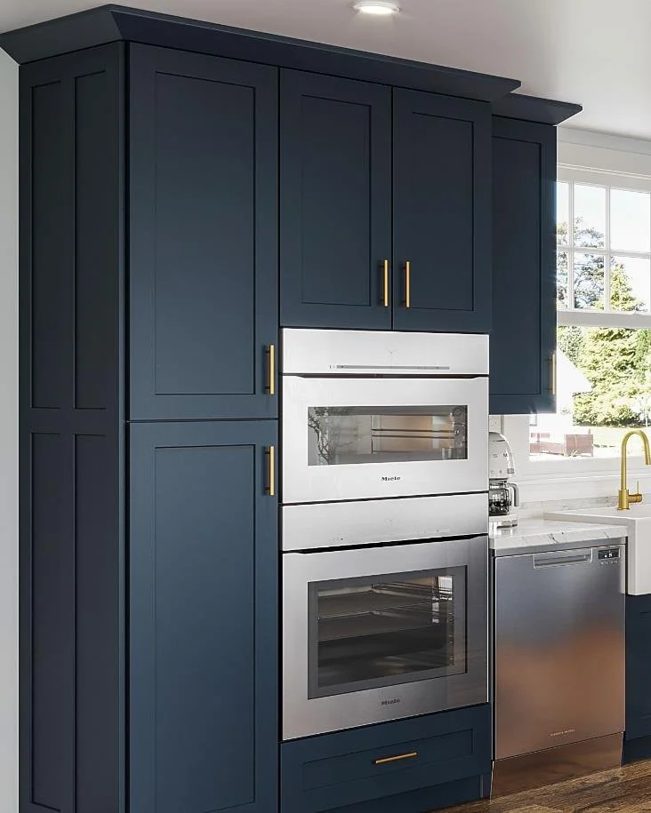 Kitchen with dark blue cabinets, stainless steel double oven, white countertops, gold hardware, and a window with outdoor view.