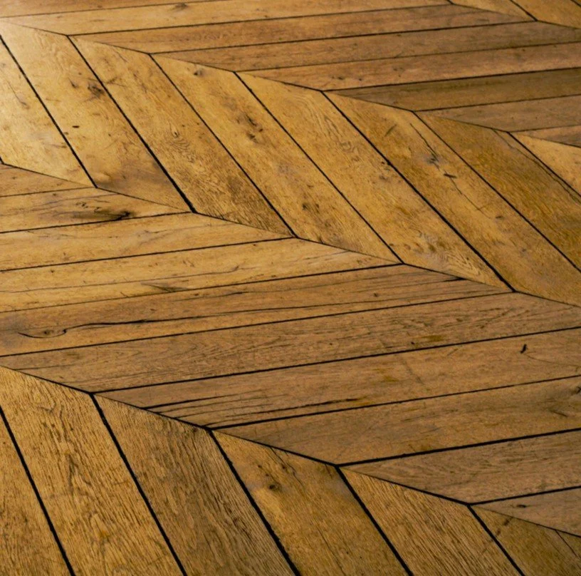 Close-up of a wooden floor with a chevron pattern.