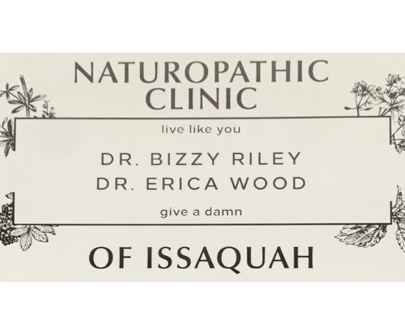 A sign for a naturopathic clinic in Issaquah, featuring the names Dr. Bizzy Riley and Dr. Erica Wood, with decorative plant illustrations.
