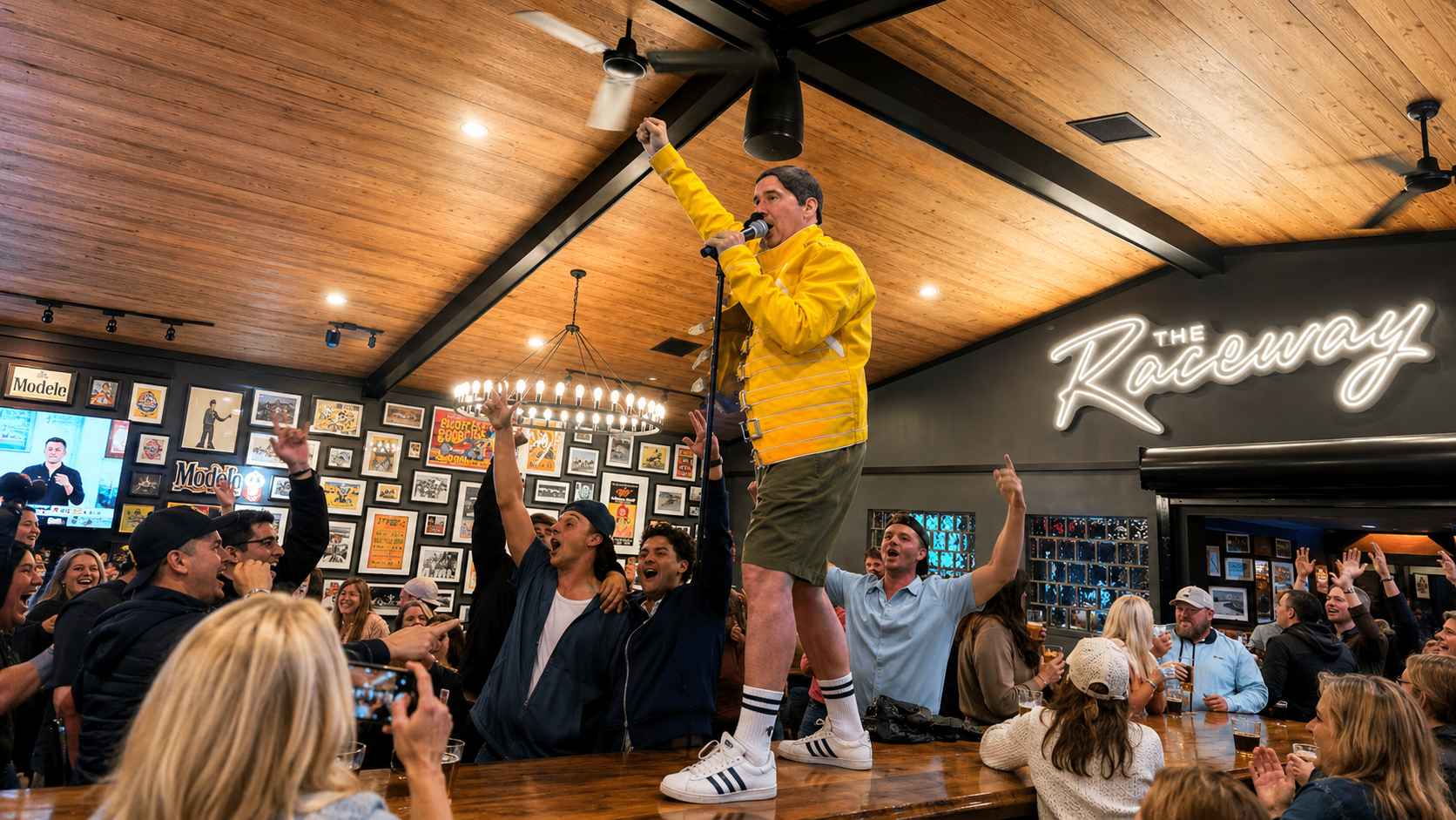 Live Music at The Raceway Restaurant. Performer stands on a bar, holding a microphone and raising a fist as he performs or cheers, surrounded by a cheering crowd.