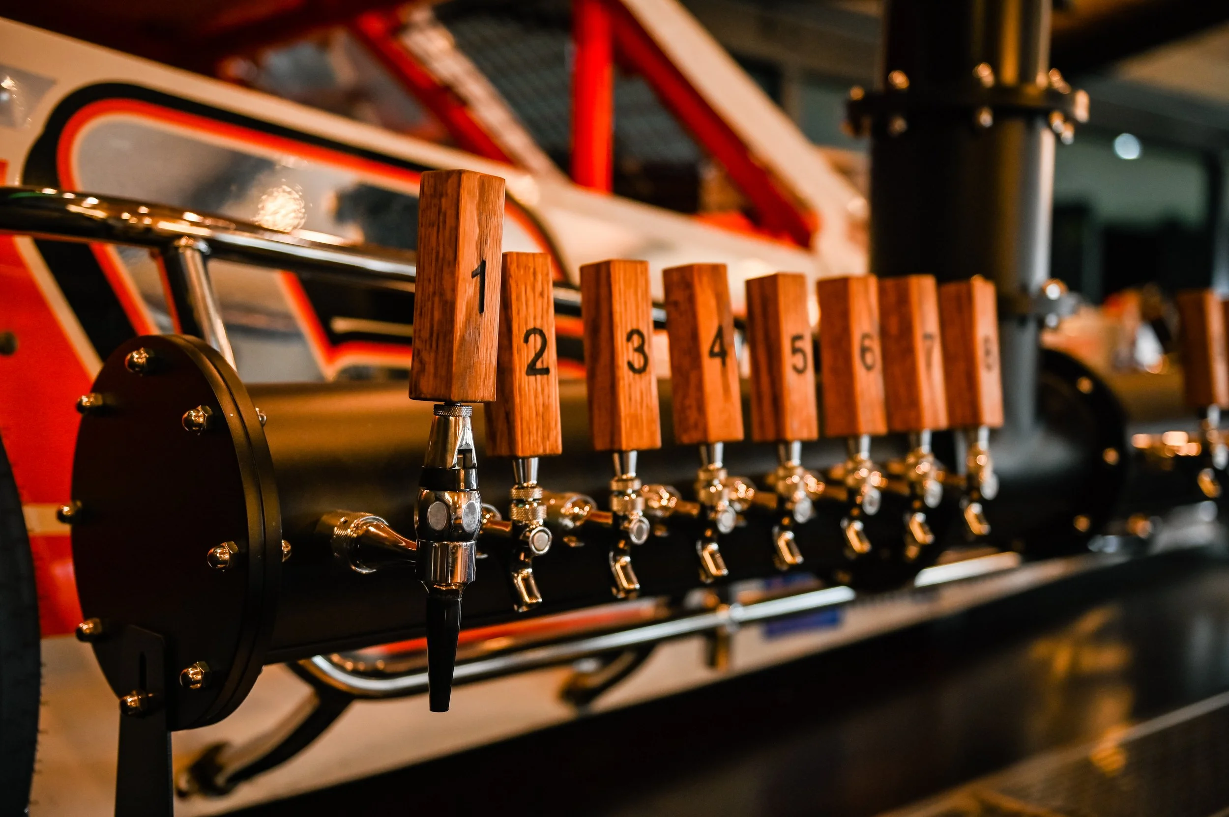 Close-up of a row of wooden levers numbered 1 to 6, attached to a mechanism, with a blurred background of a retro arcade game or pinball machine.