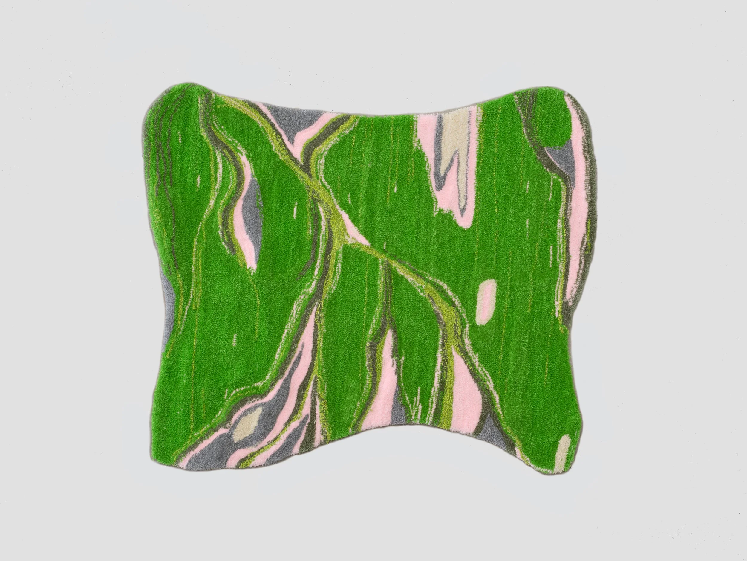 A decorative rug with a swirling green, pink, and gray abstract pattern on a plain white background.