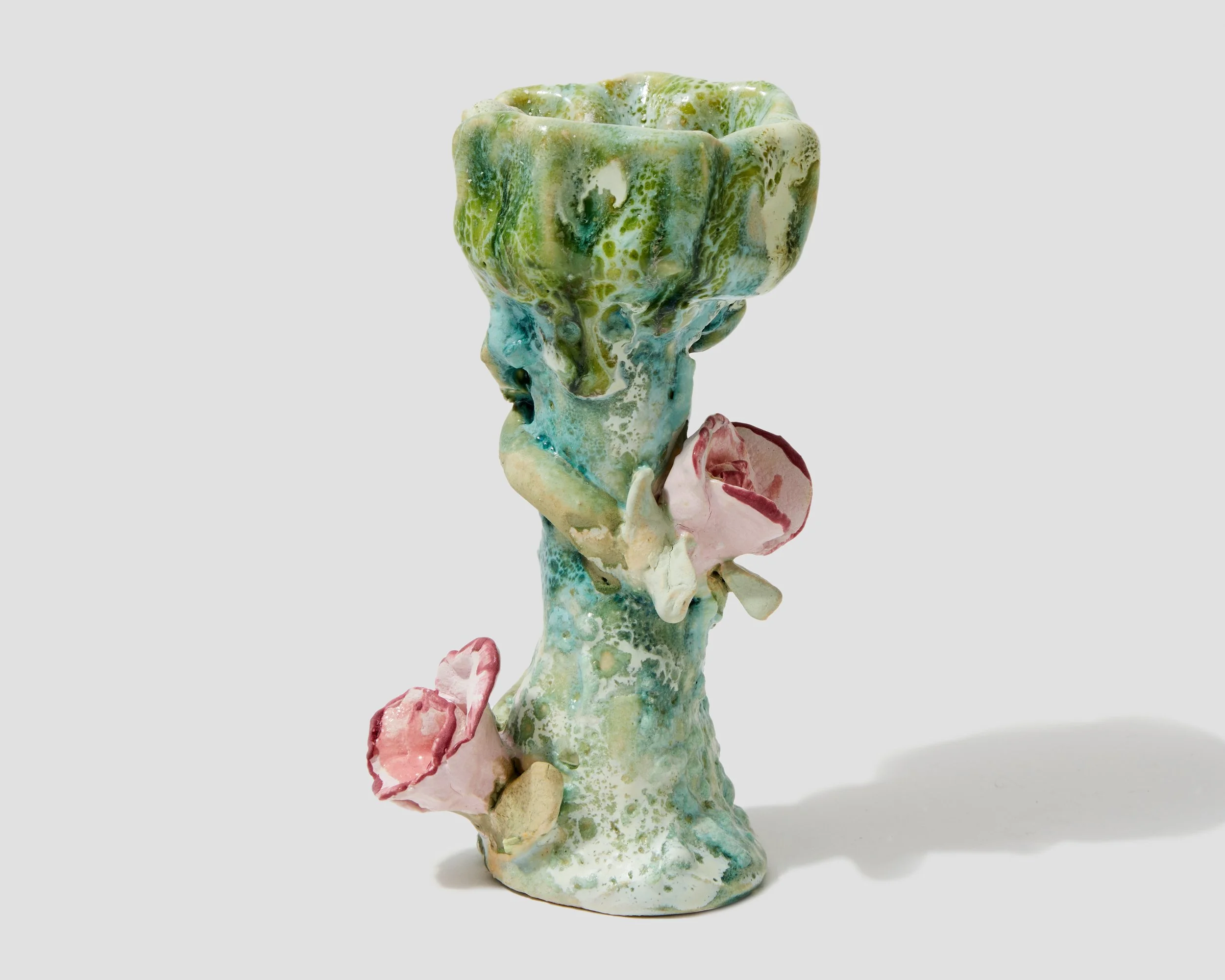 A colorful ceramic candlestick holder resembling a tree with branches and flowers, painted in shades of green, pink, and cream.