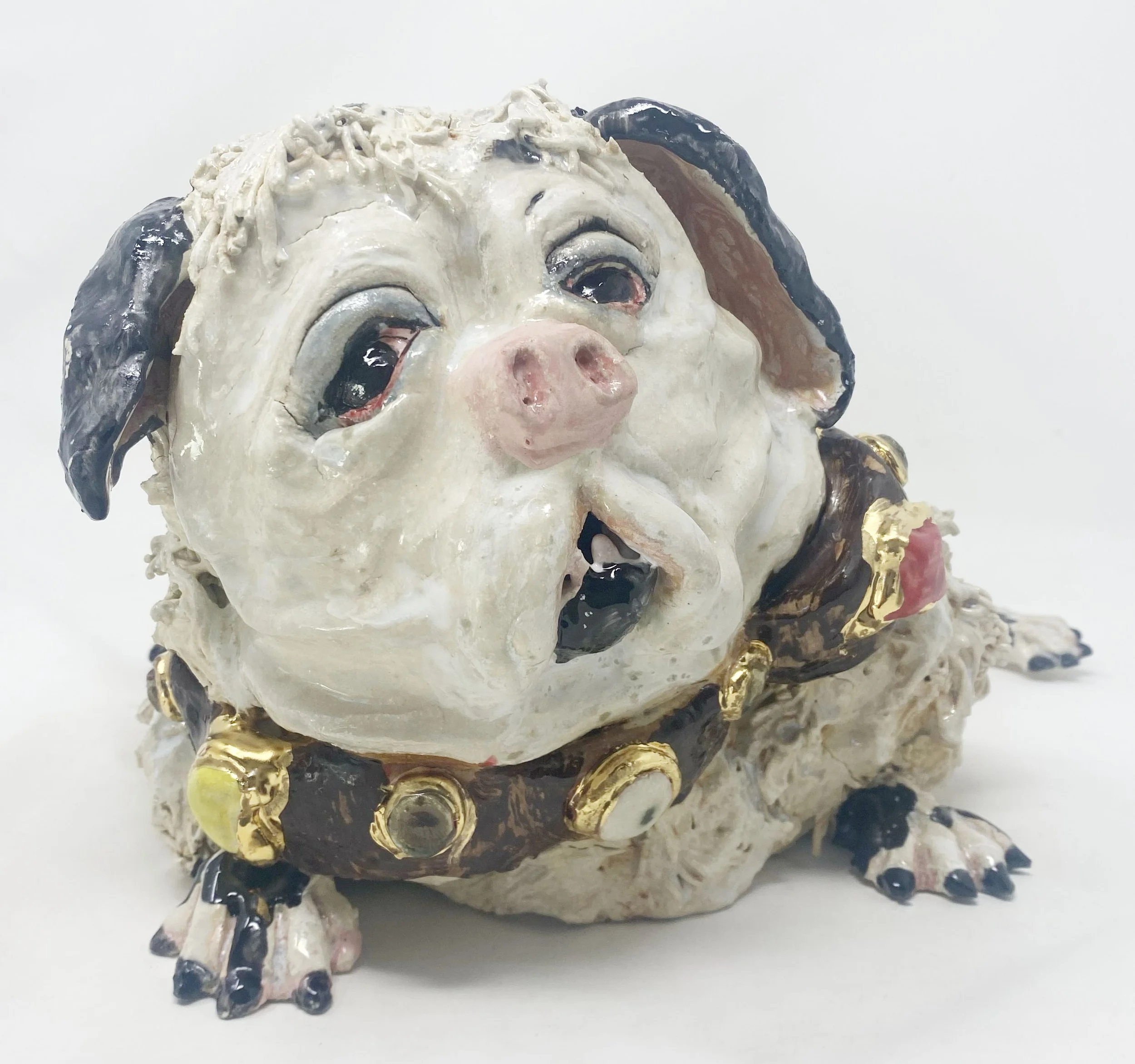 A ceramic sculpture of a child's face with curly hair, pink cheeks, and detailed features, set against a plain white background.