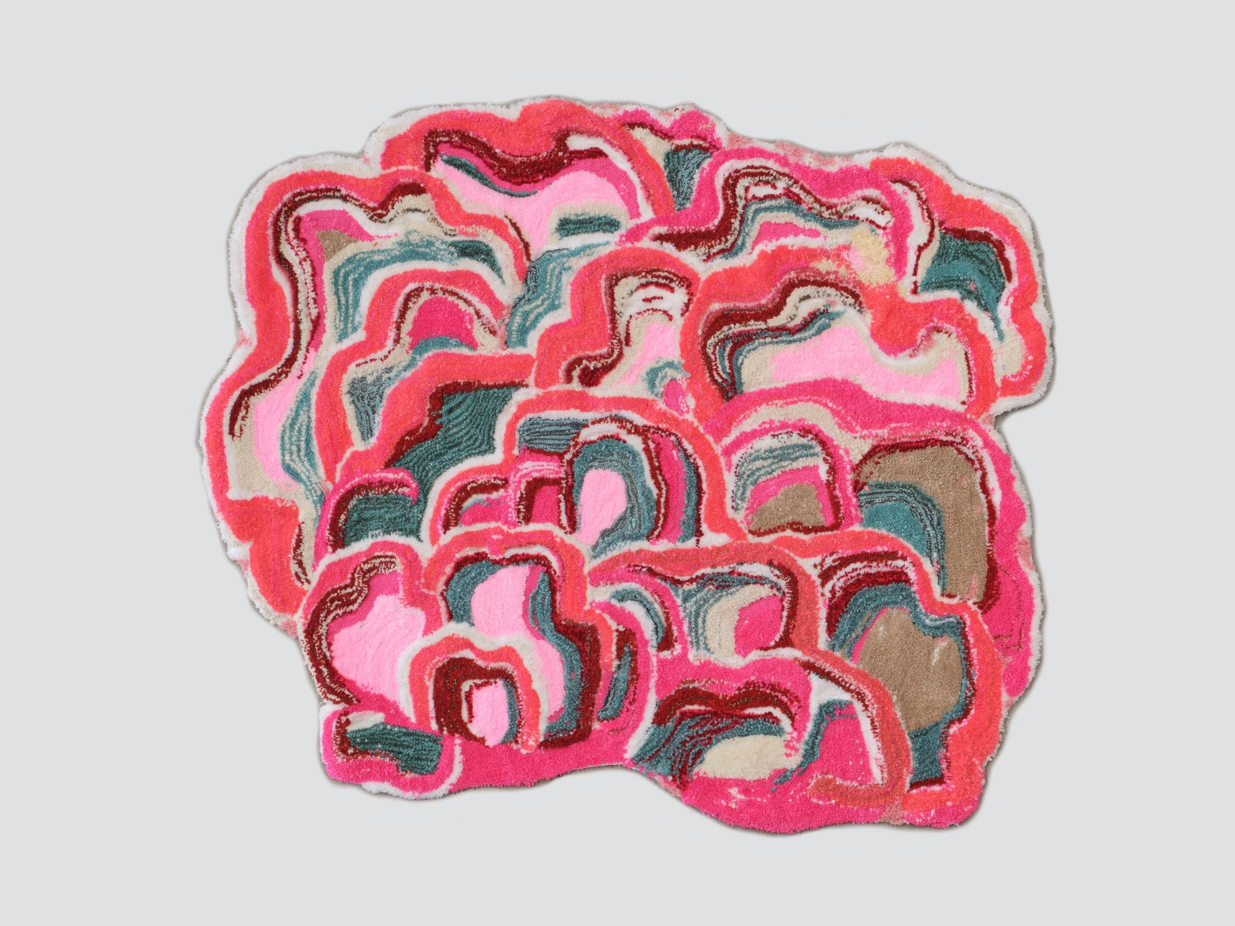 Colorful abstract rug with pink, red, green, white, and beige swirls and contours on a light background.