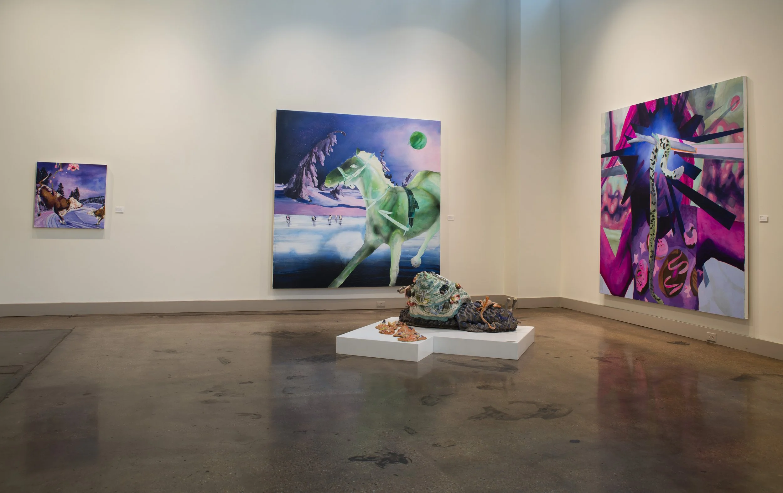Art gallery with three colorful paintings on white walls and a sculpture on a white pedestal in the center of the room.