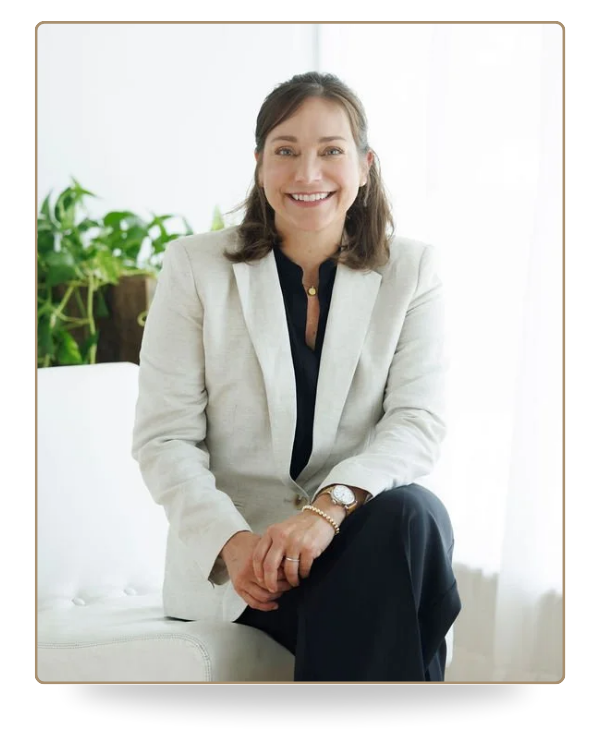 Farrah Chrstos, LCSW, LISW, sitting on a white sofa wearing a beige blazer and smiling