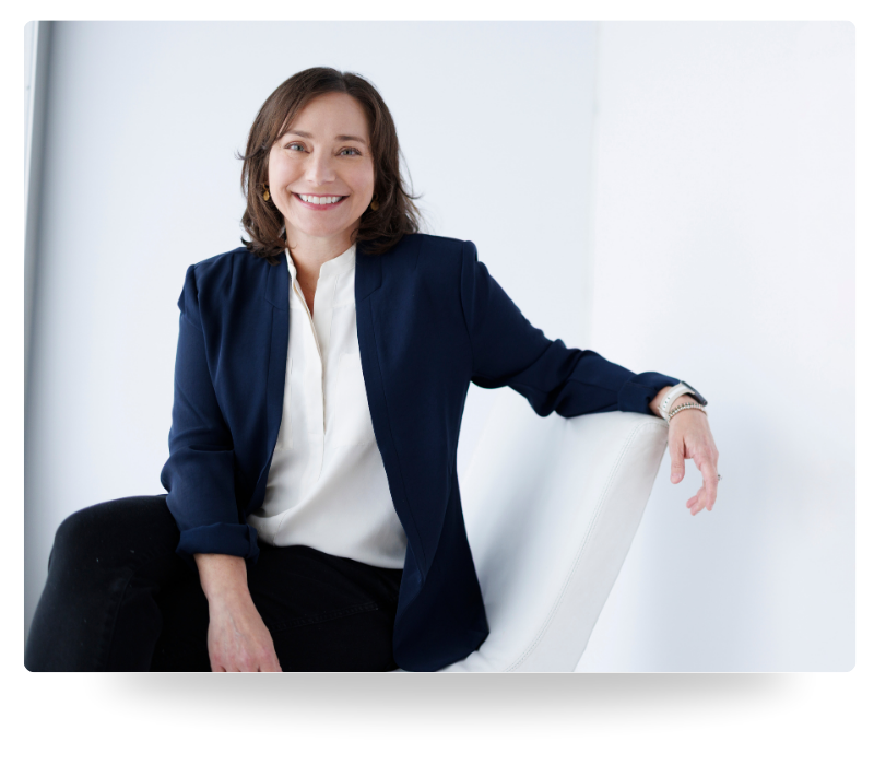 Farrah Chrstos, LCSW, LISW, MSW smiling, sitting against a white background and wearing a navy blazer