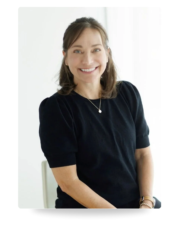 Farrah Chrstos, LCSW, LISW sitting in a chair and smiling, offering therapy, coaching and mediation