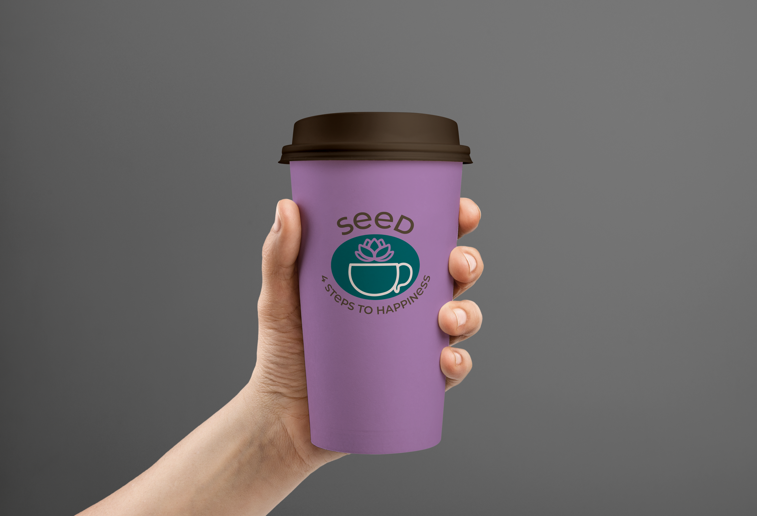 Hand hält einen lila Kaffeebecher mit braunem Deckel, Beschriftung "Seed" mit dem Logo des fiktiven Cafés aus Berlin.