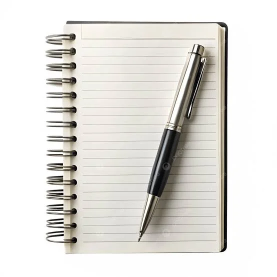 Open spiral notebook with lined pages and a silver and black pen resting on top.