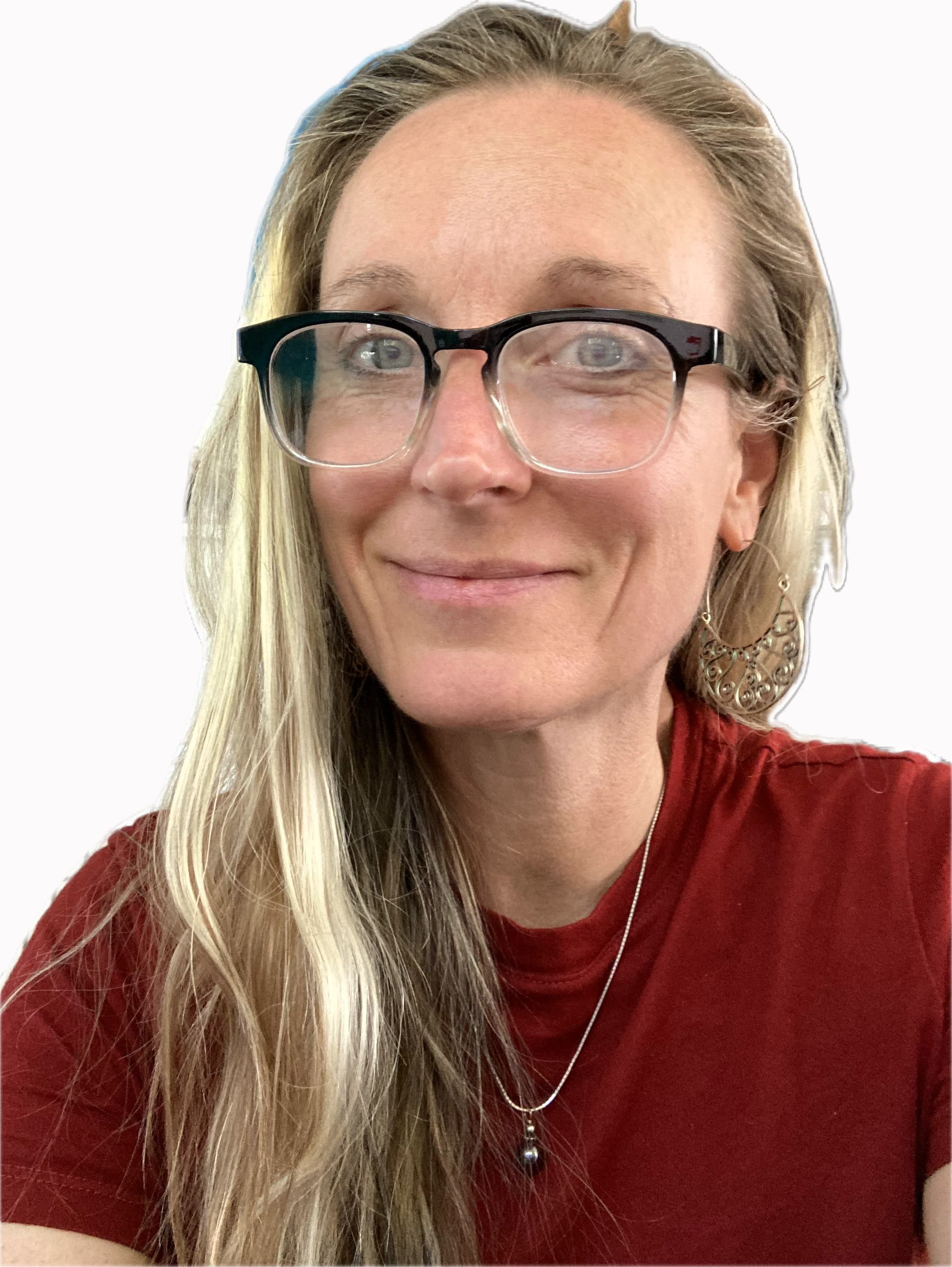Close-up of a woman with long blonde hair wearing glasses, a red top, earrings, and a necklace, smiling with a white background.