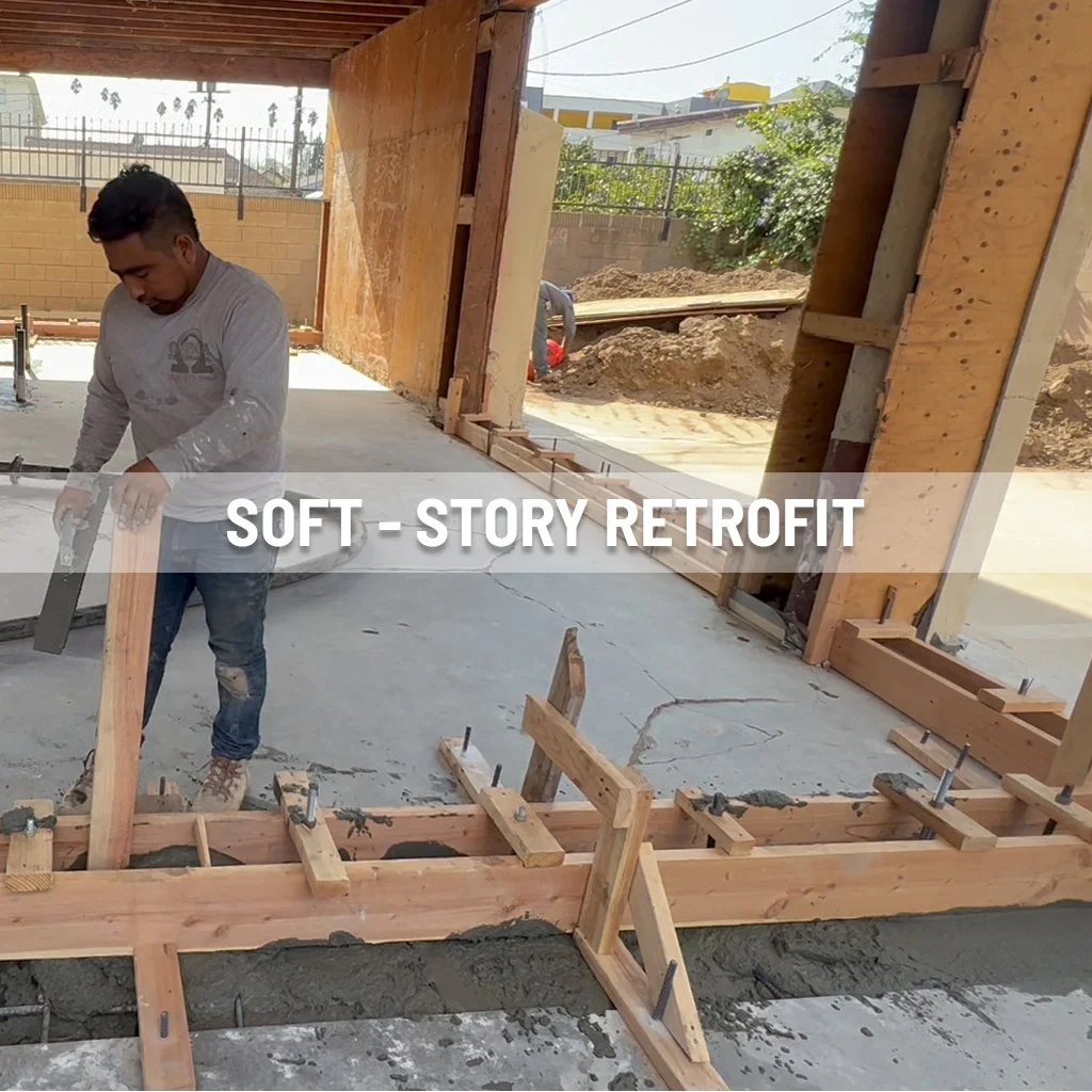 A man working on framing using wood and construction tools in a house renovation project, with unfinished walls and construction materials visible.