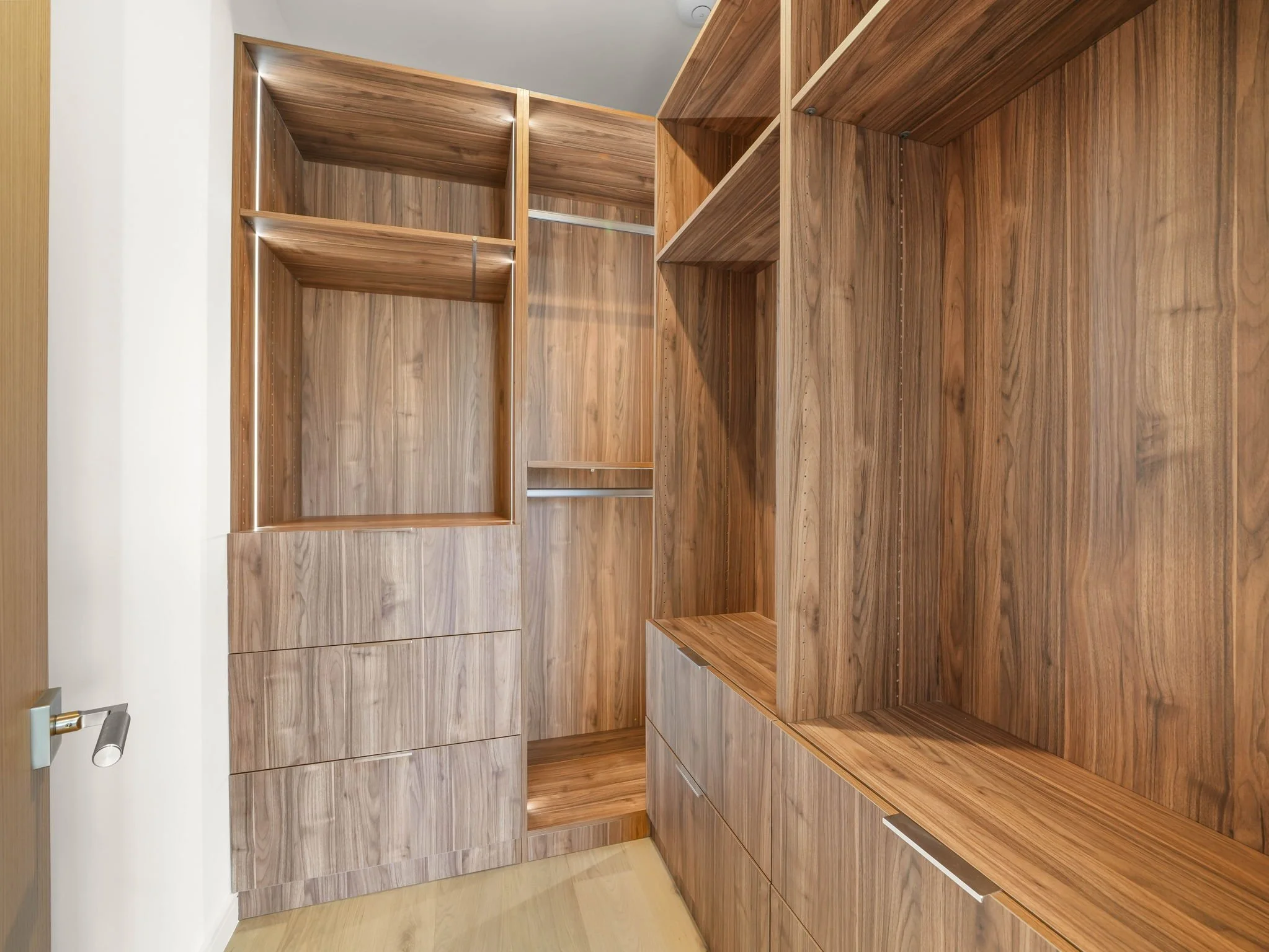 Empty wooden closet or shelving unit with multiple compartments and space for storage.