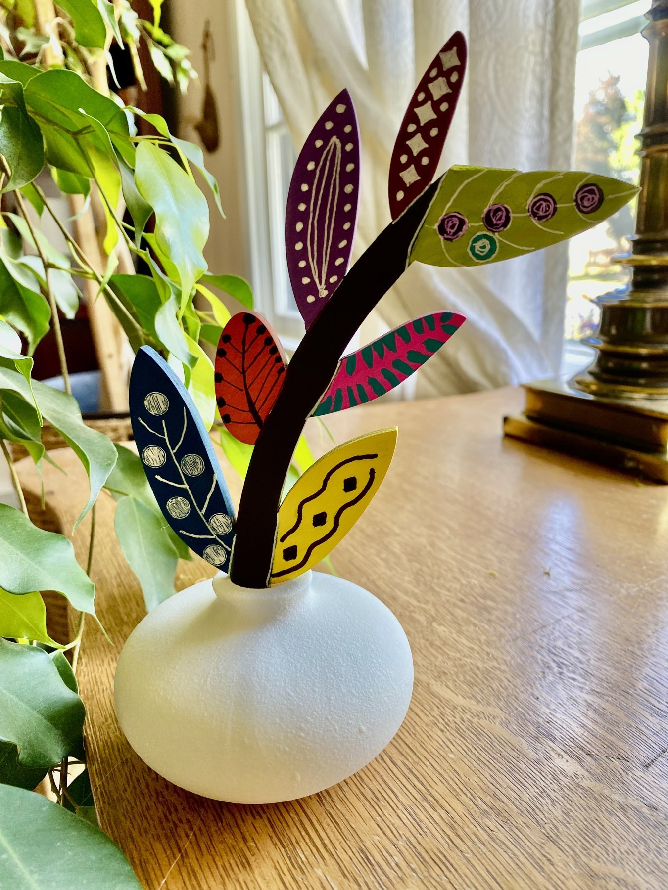 Hand-painted leaf feathers in a white bud vase