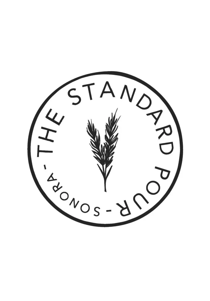 A circular logo with the text 'The Standard Pour - Sound' around the edge and a stylized plant or wheat stalk in the center.