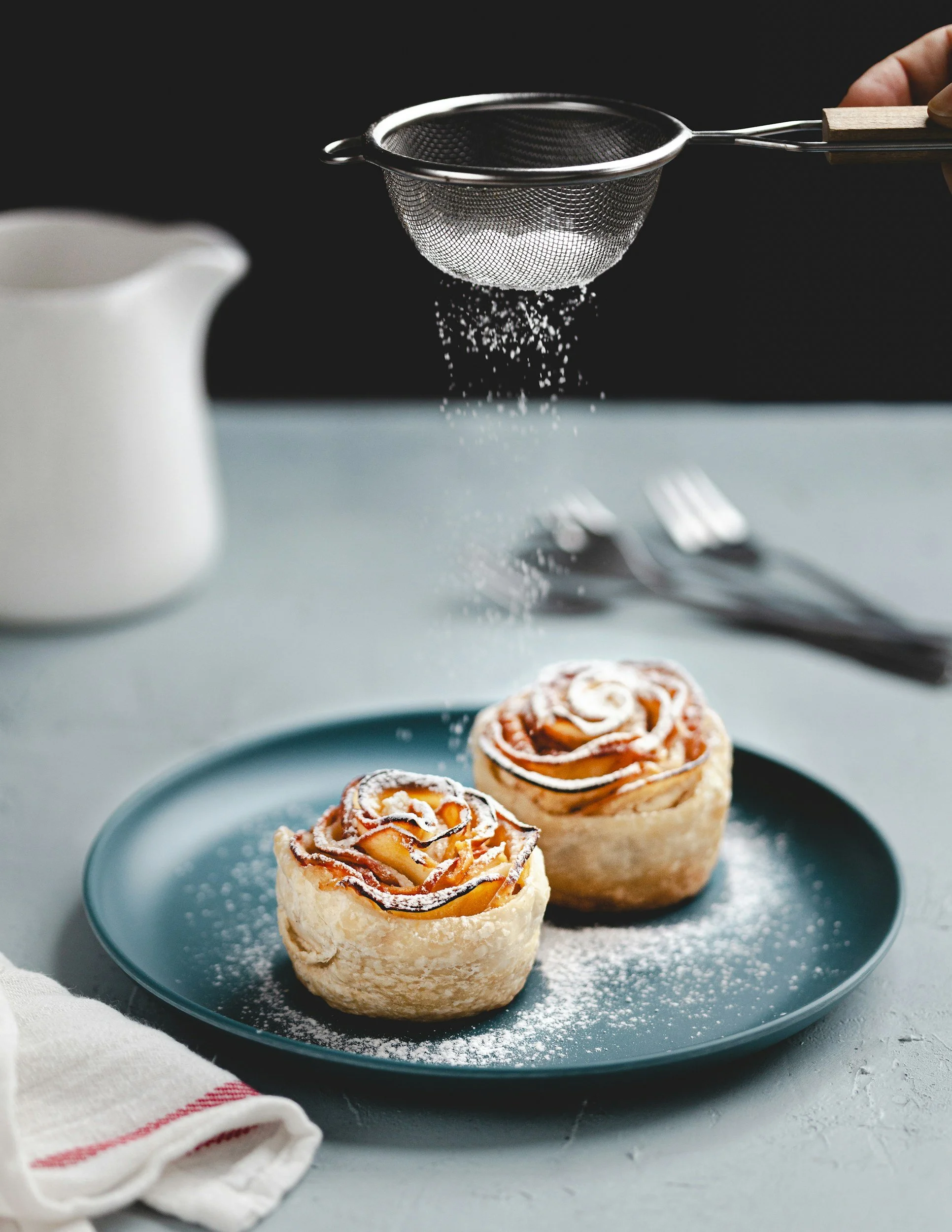 sprinkling powdered sugar on dessert