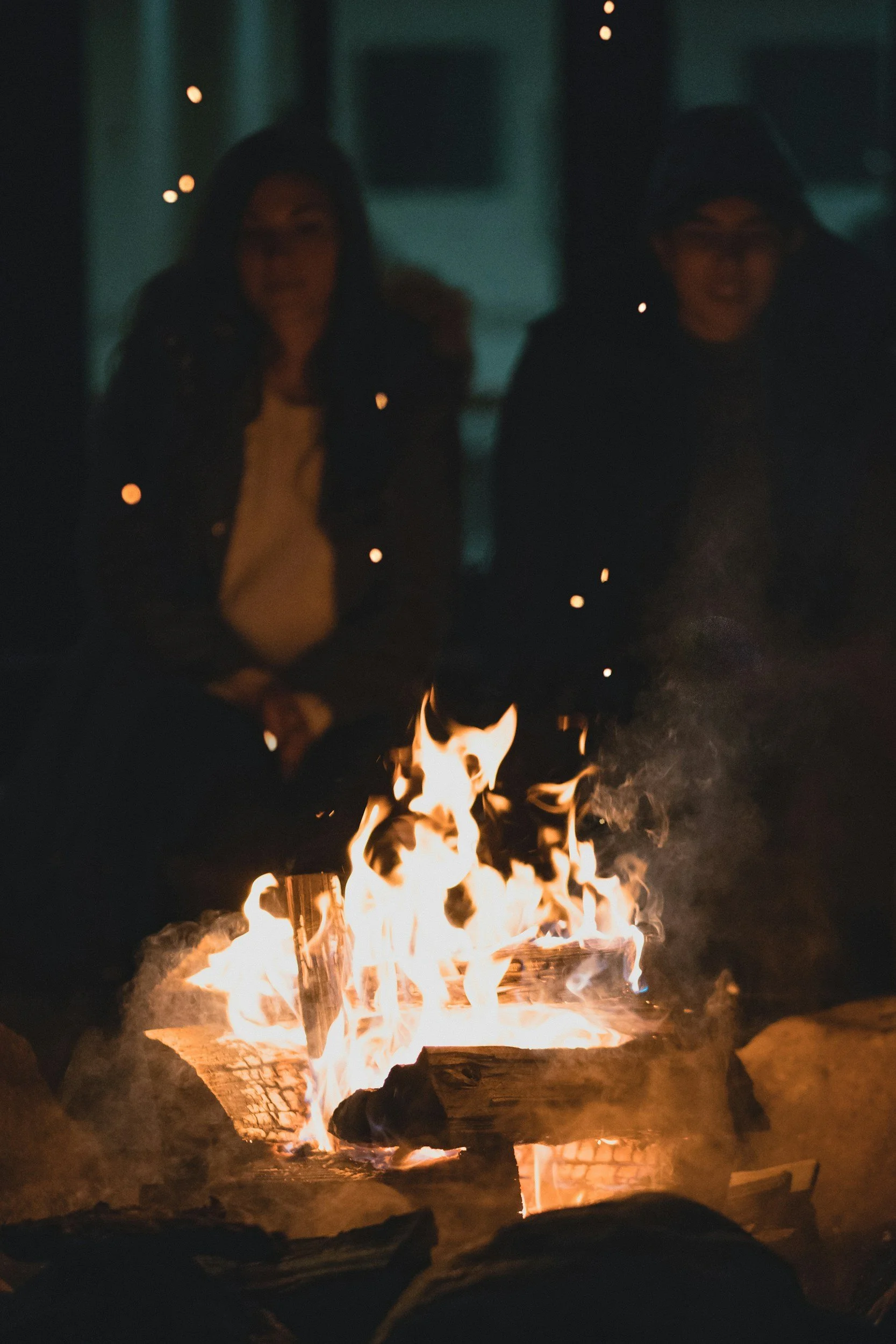 women relaxing by a campfire