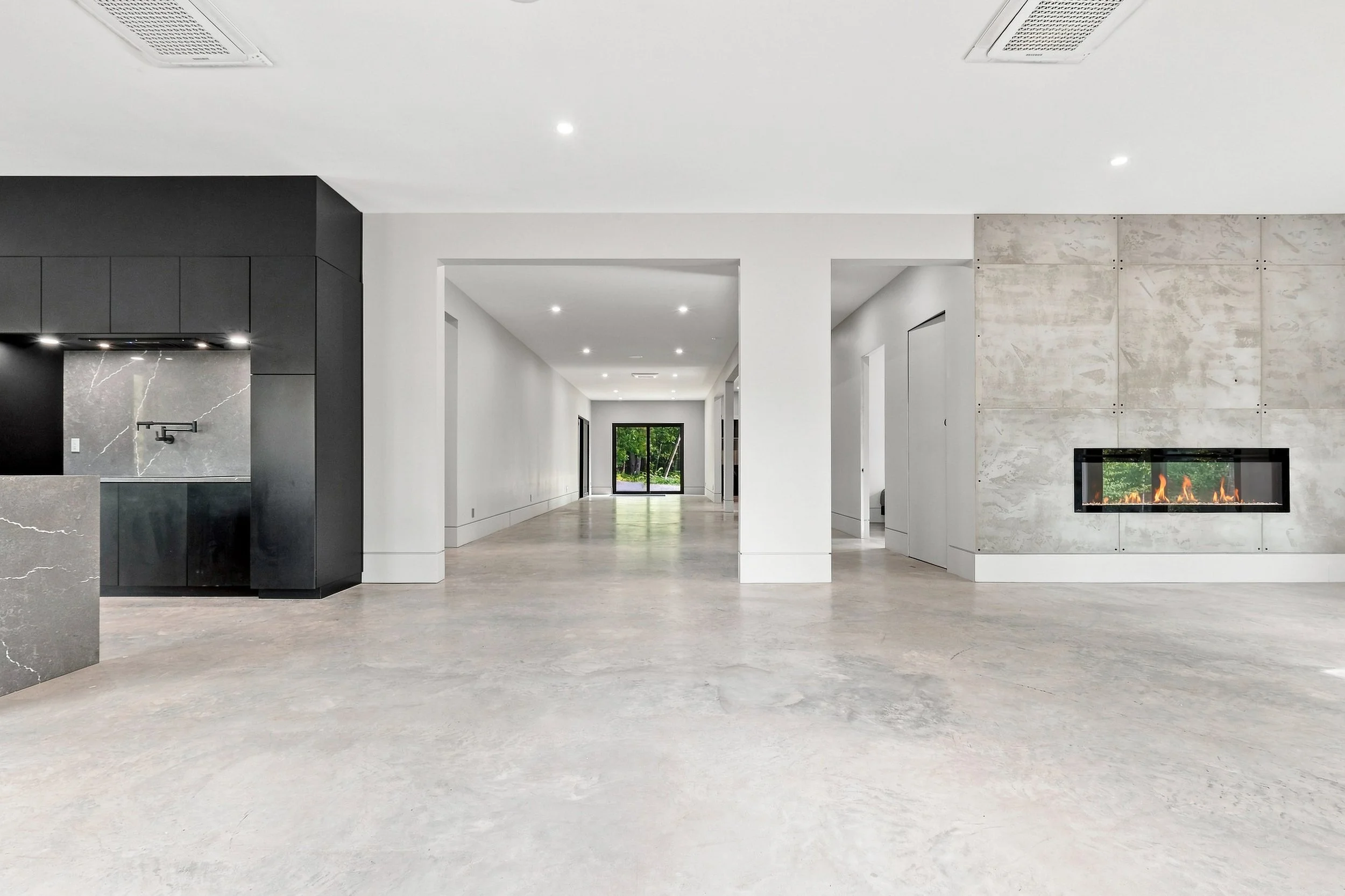 Modern open living space with concrete floor, fireplace and glass doors to the garden, Ottawa listing photography