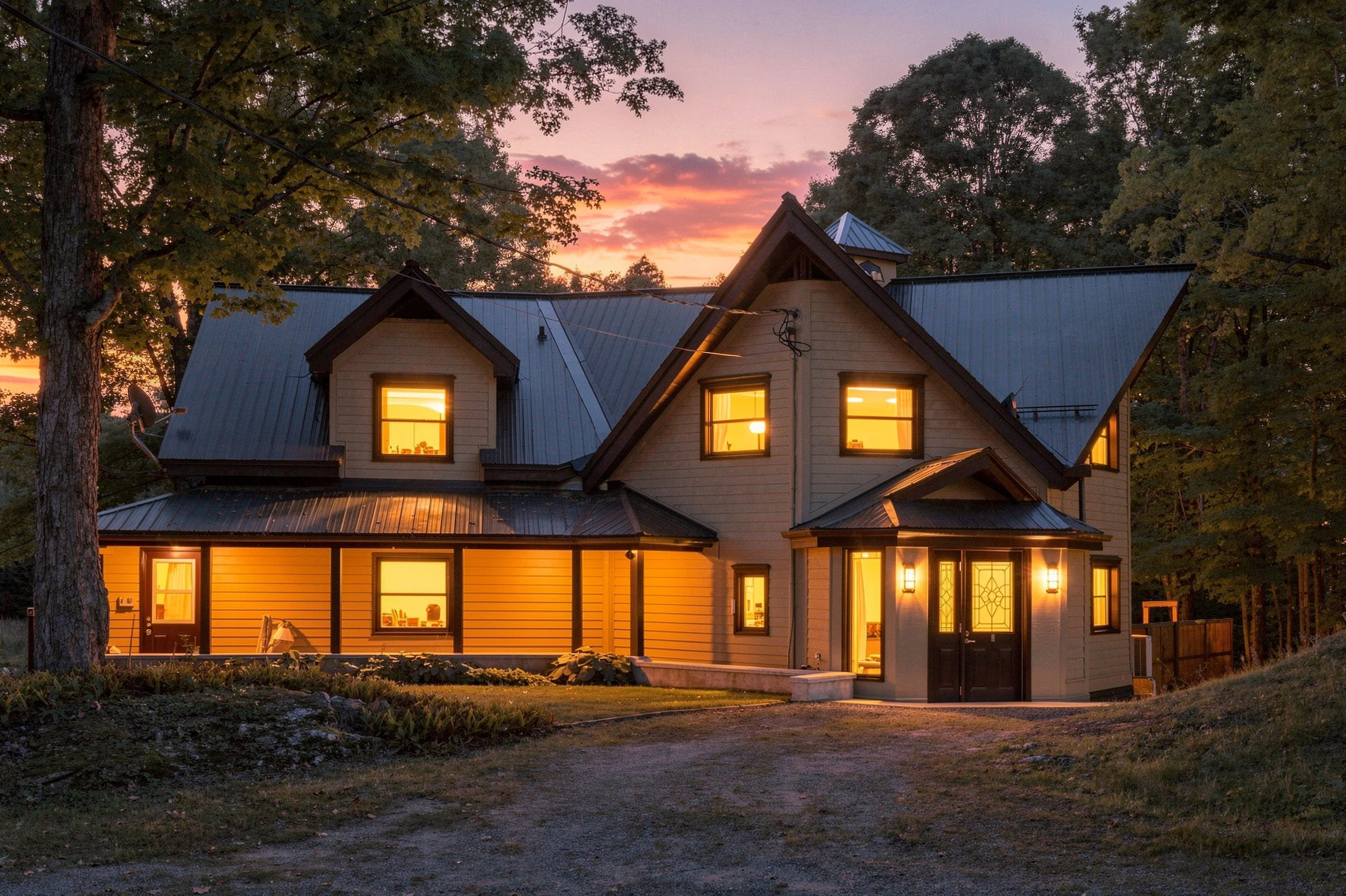 Two storey home with metal roof and glowing windows, twilight real estate exterior photo in the Ottawa area