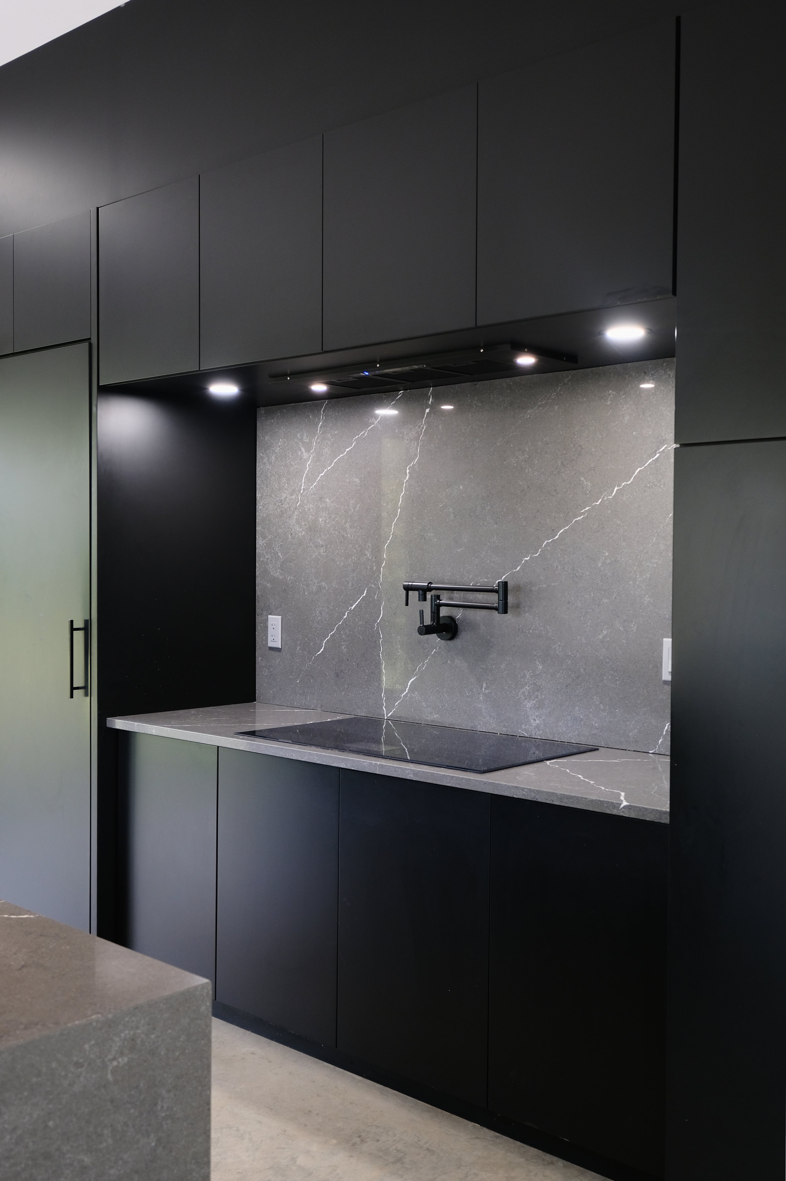 Modern black kitchen with gray marble backsplash, Ottawa real estate listing photo by NewGlimpse