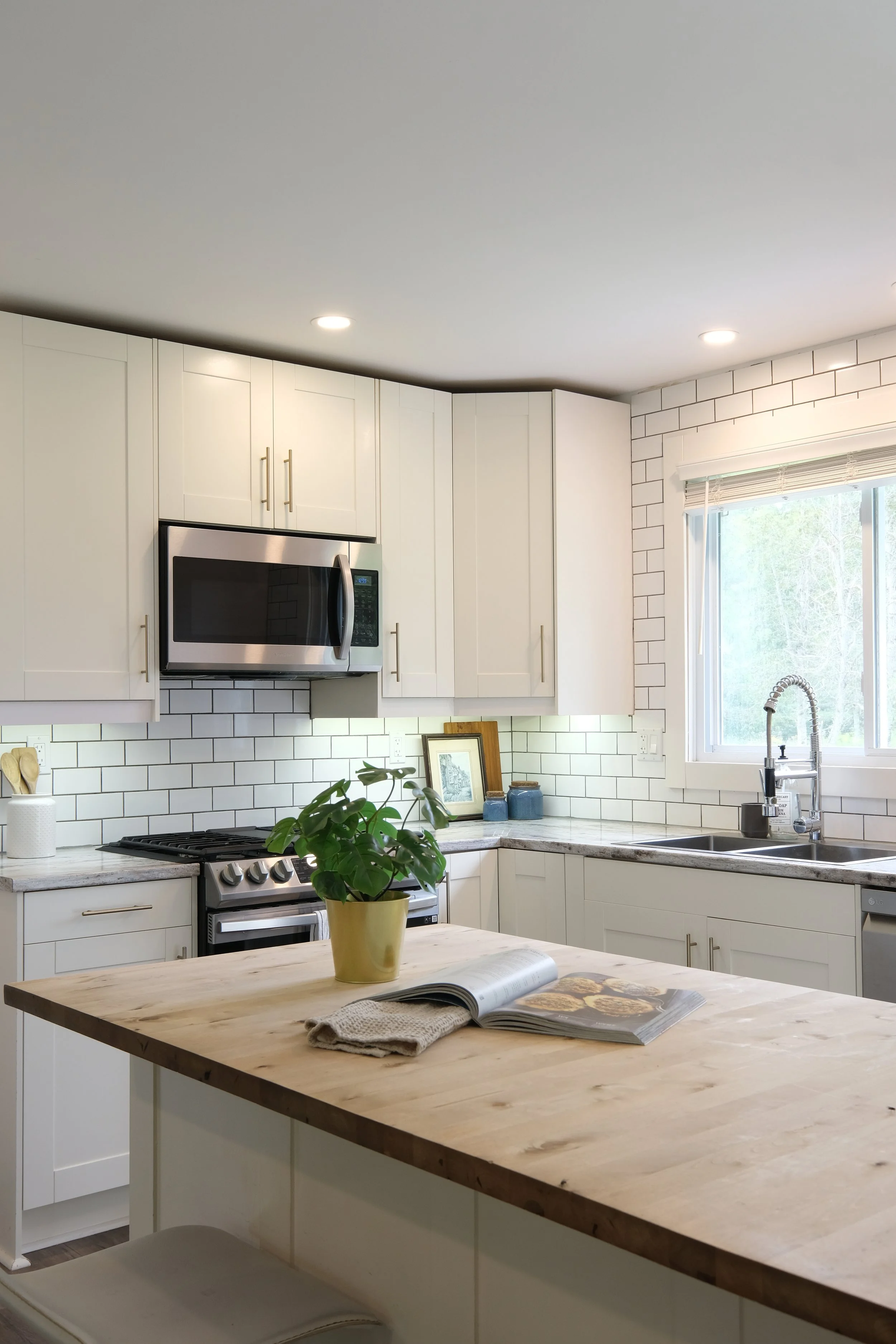 Modern white kitchen with stainless steel appliances and wooden island, real estate photography in Ottawa by NewGlimpse