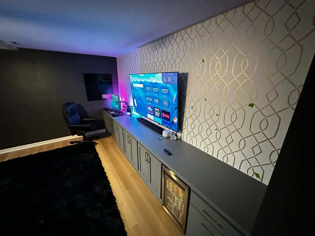 Wall-to-wall cabinetry, refrigerator encloser with a custom desk with pull-out keyboard tray. Paint color was chosen to match the look of the houses existing cabinetry. 

TGS also installed flooring and quarter rounds. 