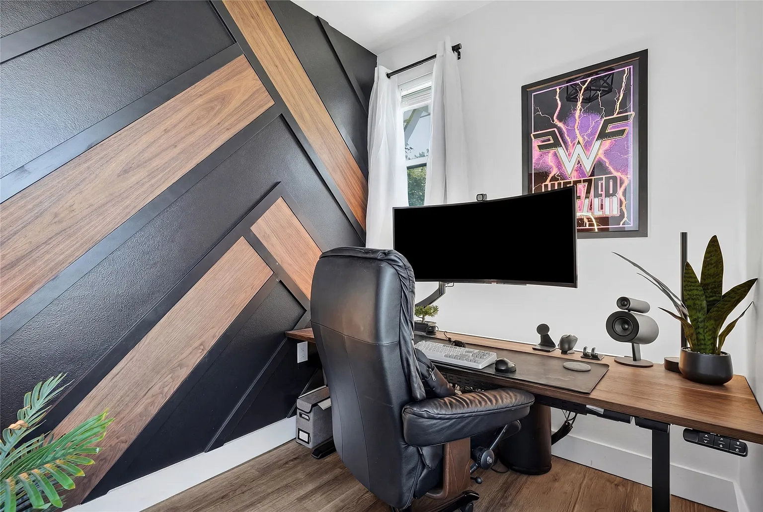 Custom walnut wall treatment, painting and custom 1 5/8" thick desktop made to stretch to within 1/2" of either wall. This gives the appearance of a built in with the flexibility of a standing desk. Custom RGB lighting throughout.