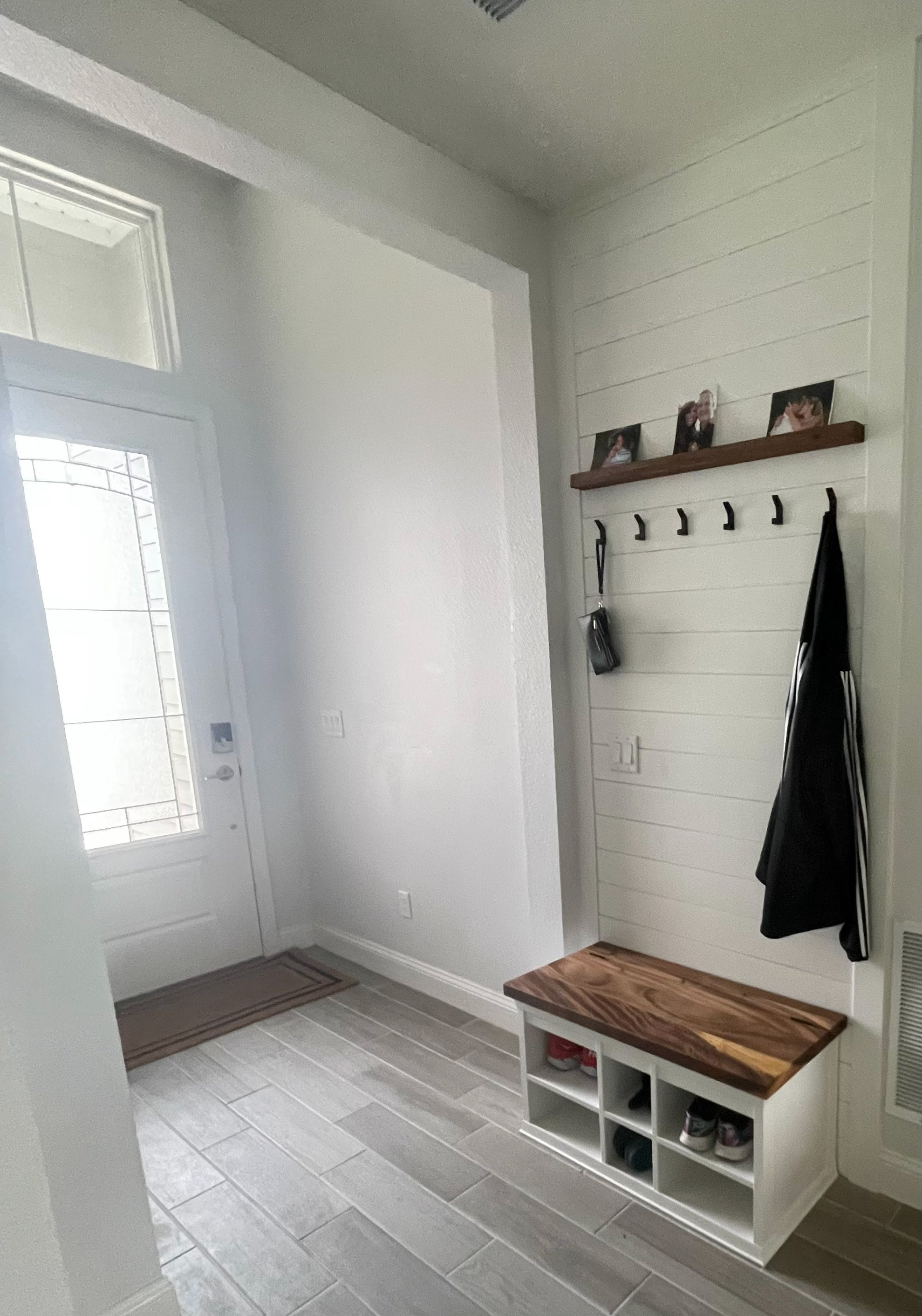 Installed and painted shiplap accent wall. Saman hardwood bench seat and wooden shelf. Shoe and bench seat storage.