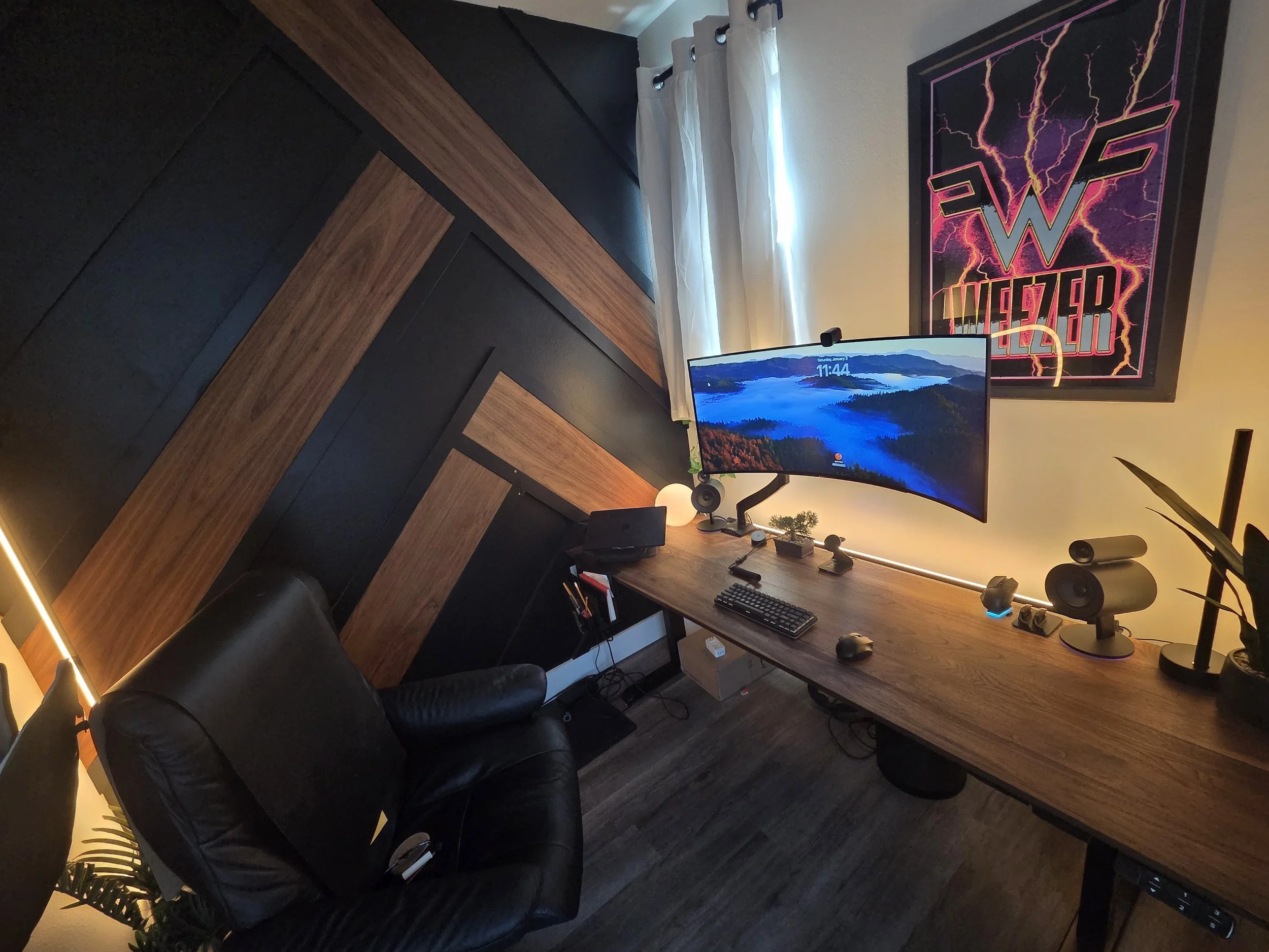 Custom walnut wall treatment, painting and custom 1 5/8" thick desktop made to stretch to within 1/2" of either wall. This gives the appearance of a built in with the flexibility of a standing desk. Custom RGB lighting throughout.