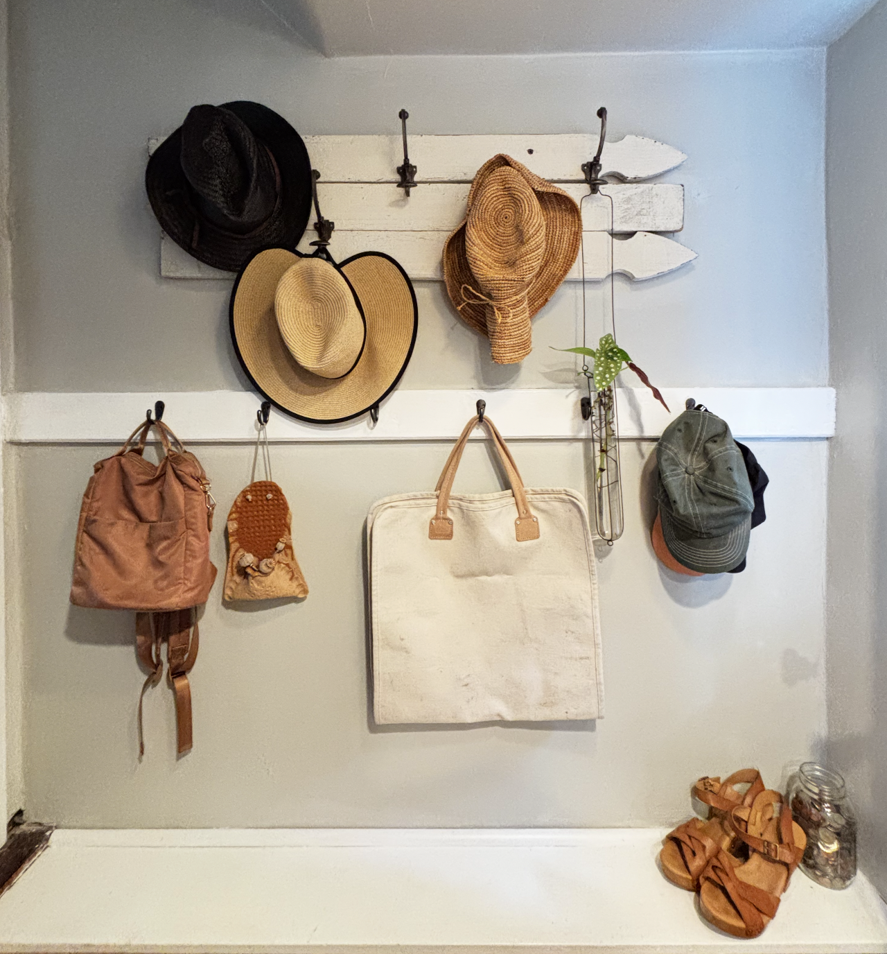 Old fence paneling repurposed as a coat hook mount and some antique hooks gifted from a friend.