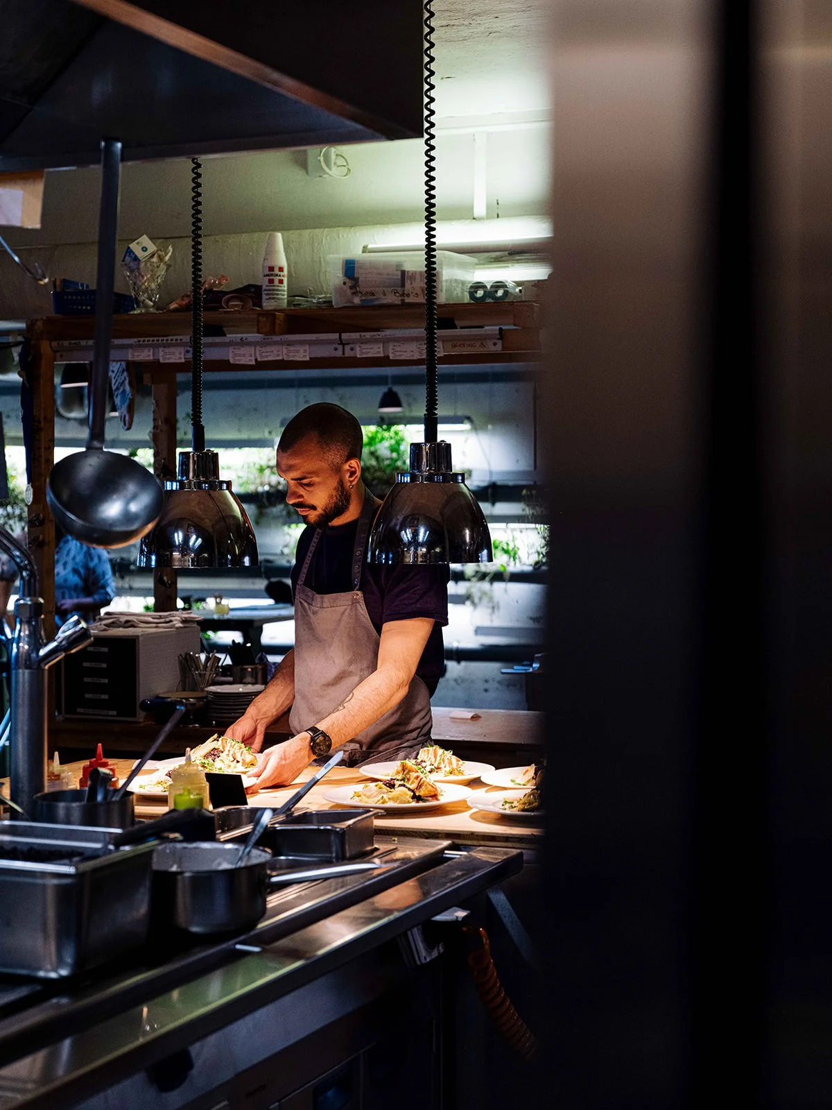 Un chef prépare des plats dans une cuisine ouverte.
