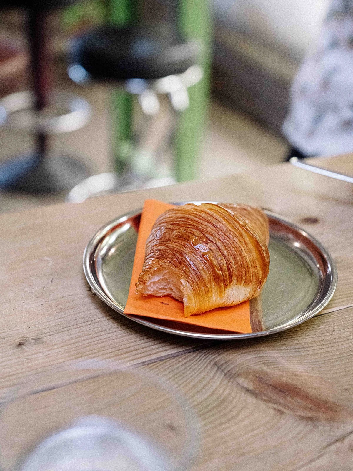 Croissant doré sur une assiette en métal sur une table en bois
