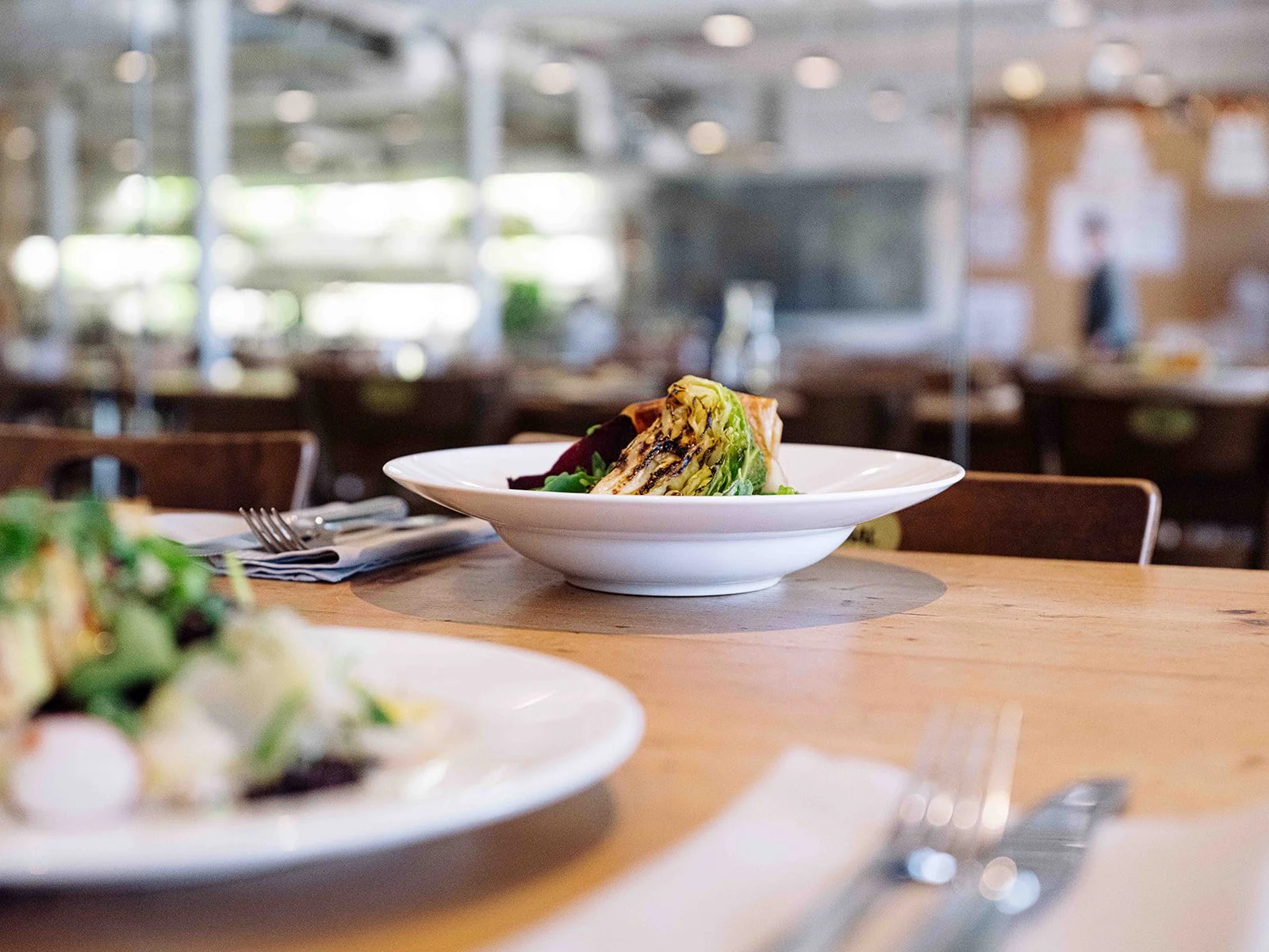 Plat de légumes grillés dans un bol blanc sur une table en bois dans un restaurant
