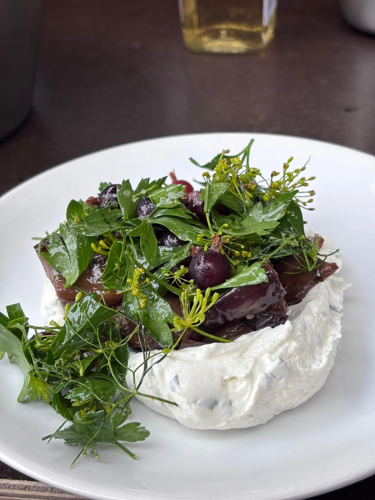 Gâteau de fromage garni de feuilles vertes, de cerises et de fleurs.