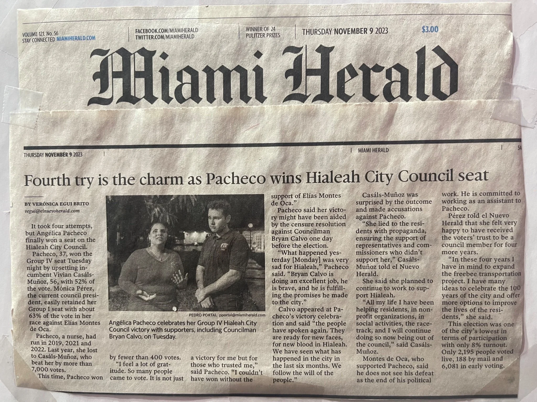 Front page of the Miami Herald newspaper with the headline about Pacheco winning the Hialeah City Council seat, featuring a black-and-white photo of Angelica Pacheco celebrating her victory with supporters.