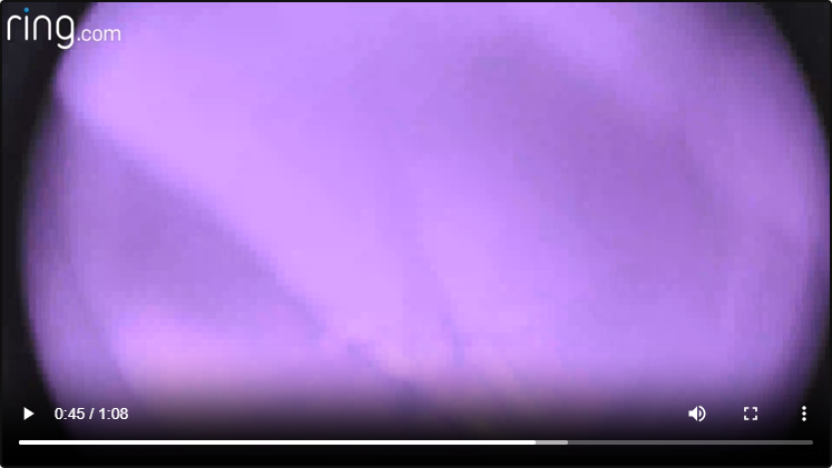 Blurred purple and black abstract background from a video still.