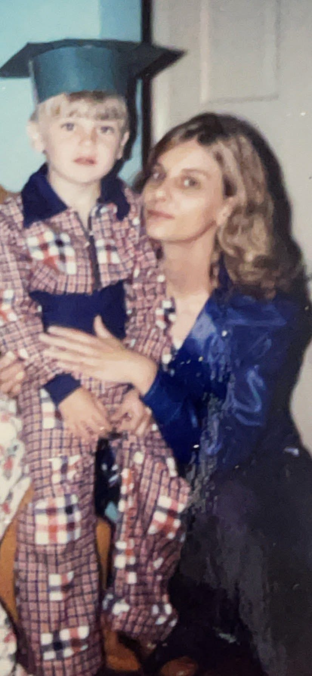 Douglas Vance as a small boy in a graduation cap, held by his mother Nancy
