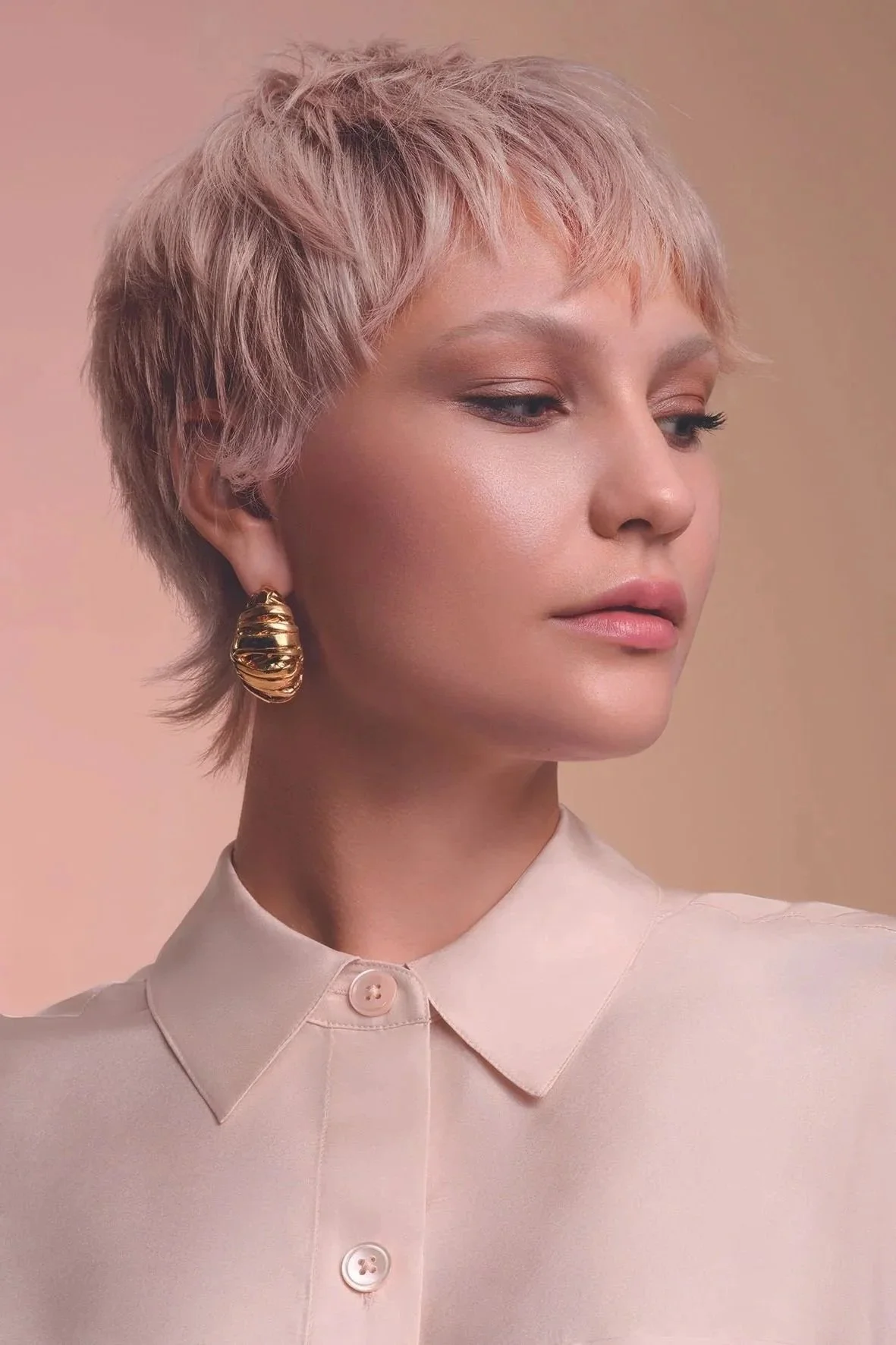 A woman with short pixie haircut, and soft strawberry blonde hair colour by Domenico Sansone.