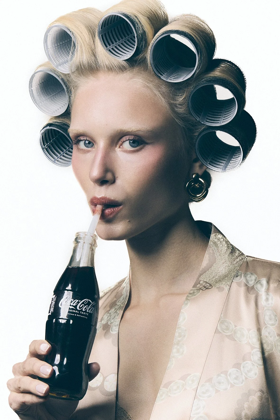 A woman with blonde hair in large hair rollers on a photoshoot set with Domenico Sansone.