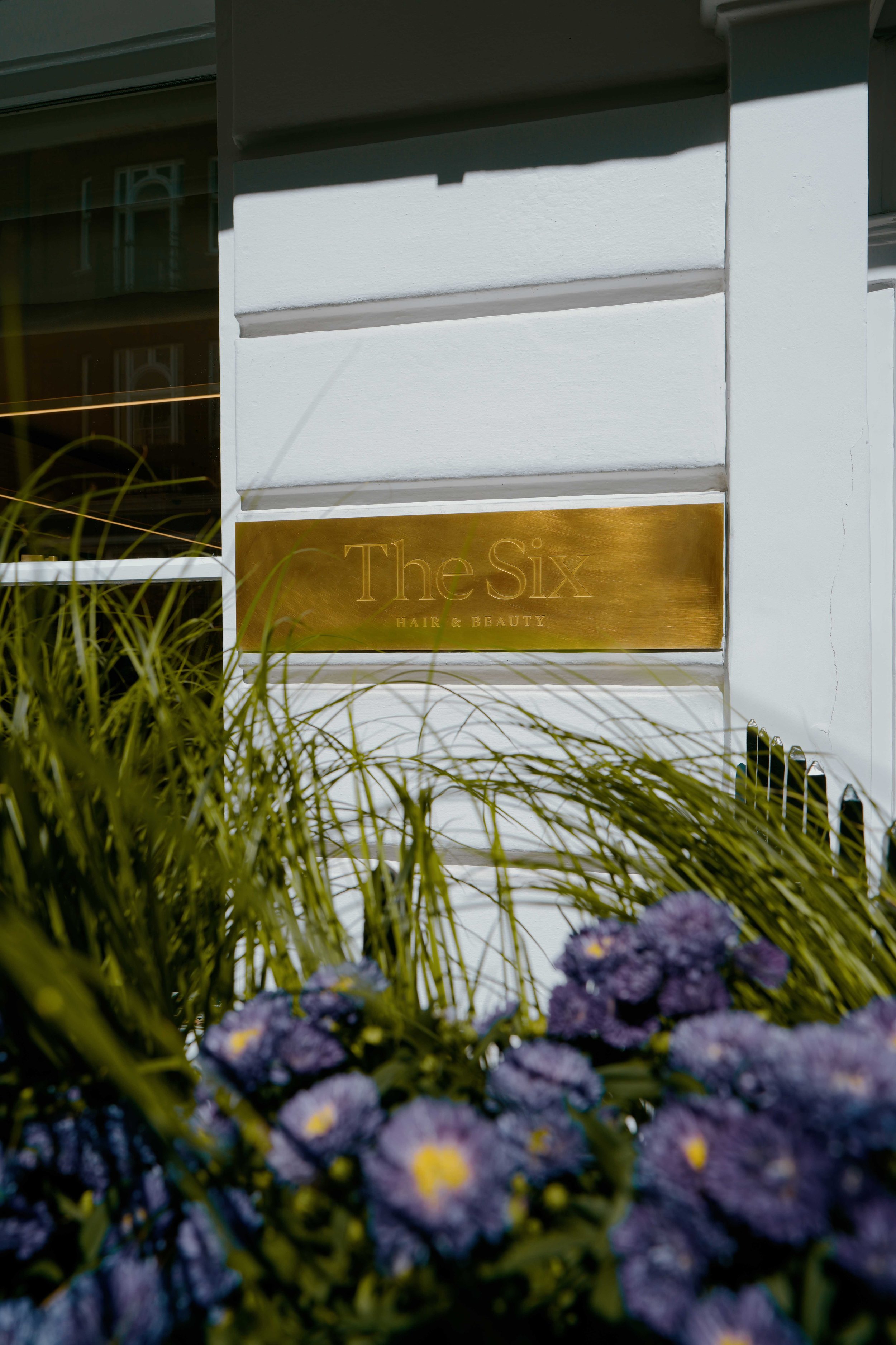 The Six hair and beauty engraved brass sign on the side of the entrance of out Townhouse in Mayfair, London.