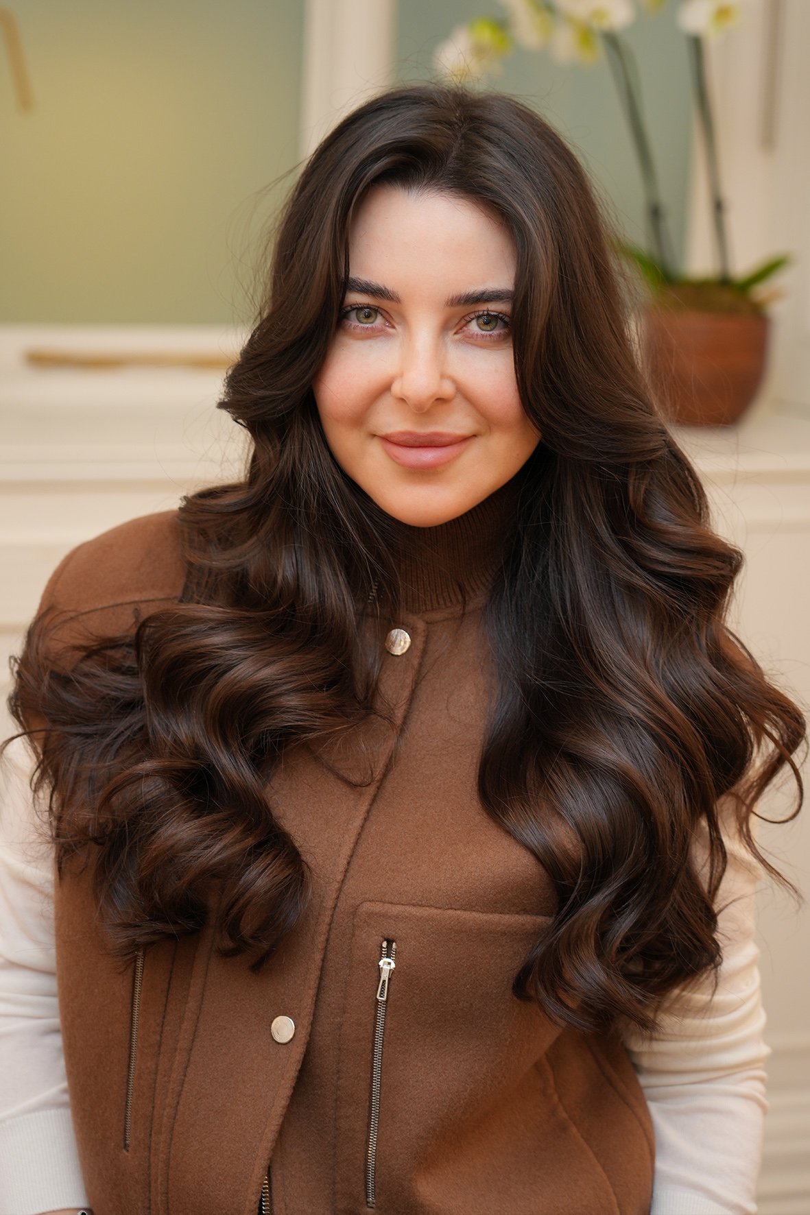 A woman with long, big wavy blow dry style by Aytaç Özbay.