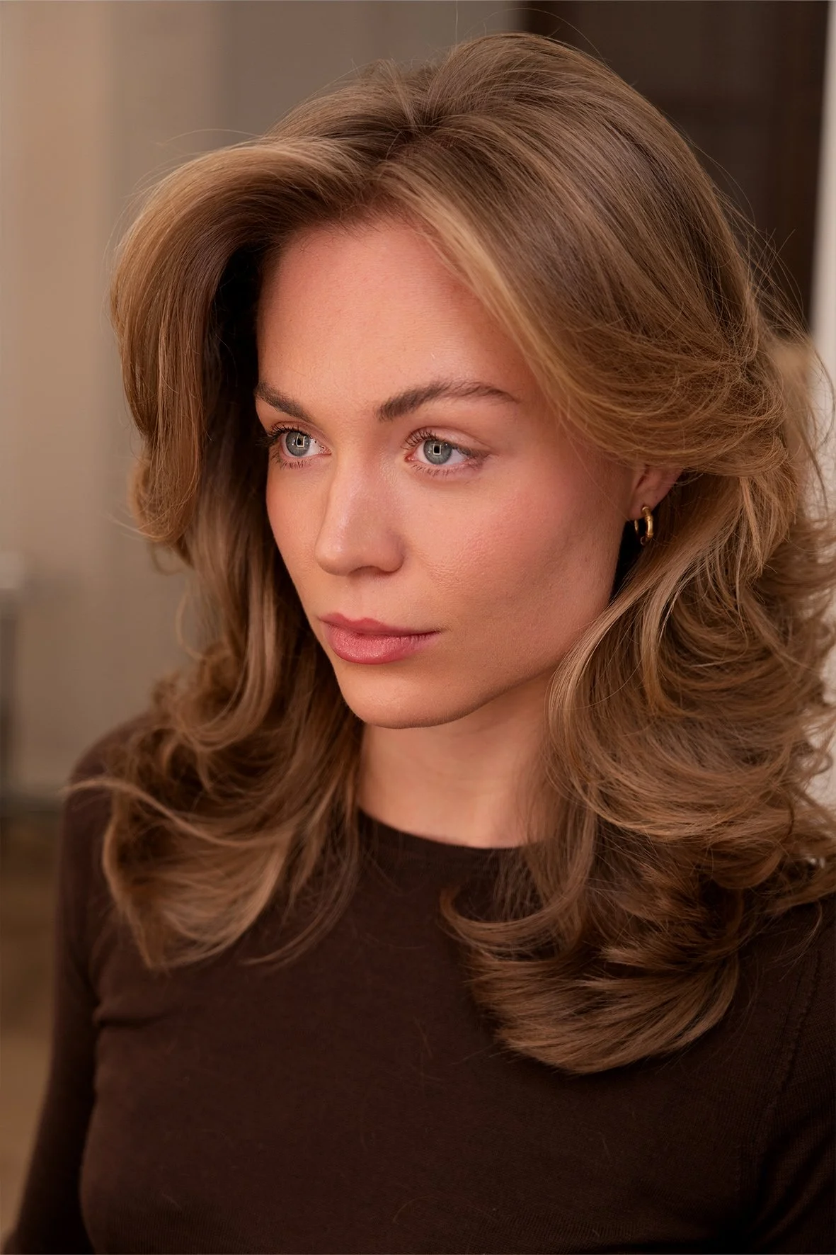 Close-up of a woman with wavy, warm light brown hair and a blonde face framing colour.