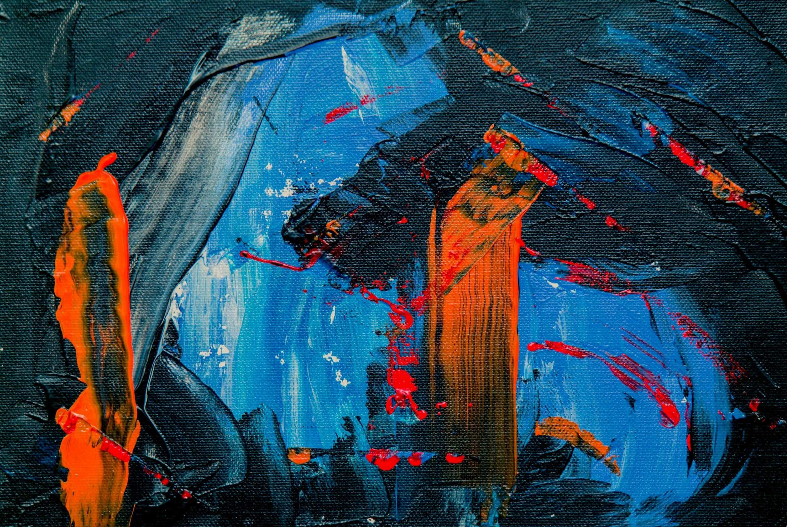Close-up of an abstract painting with bold strokes of blue, black, orange, and red paint on a textured canvas.
