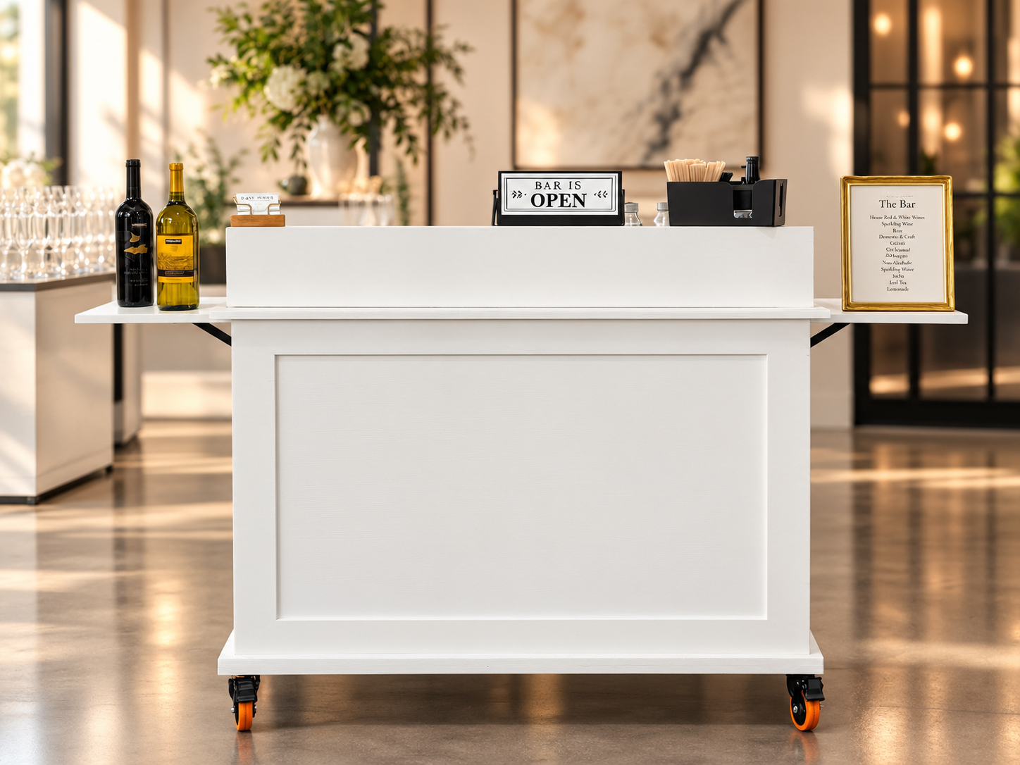 white mobile bar with white service shelf on top. black and dark gold wine bottles on the left, a printed and framed menu on the right, with a sign in the middle reading "bar is open"