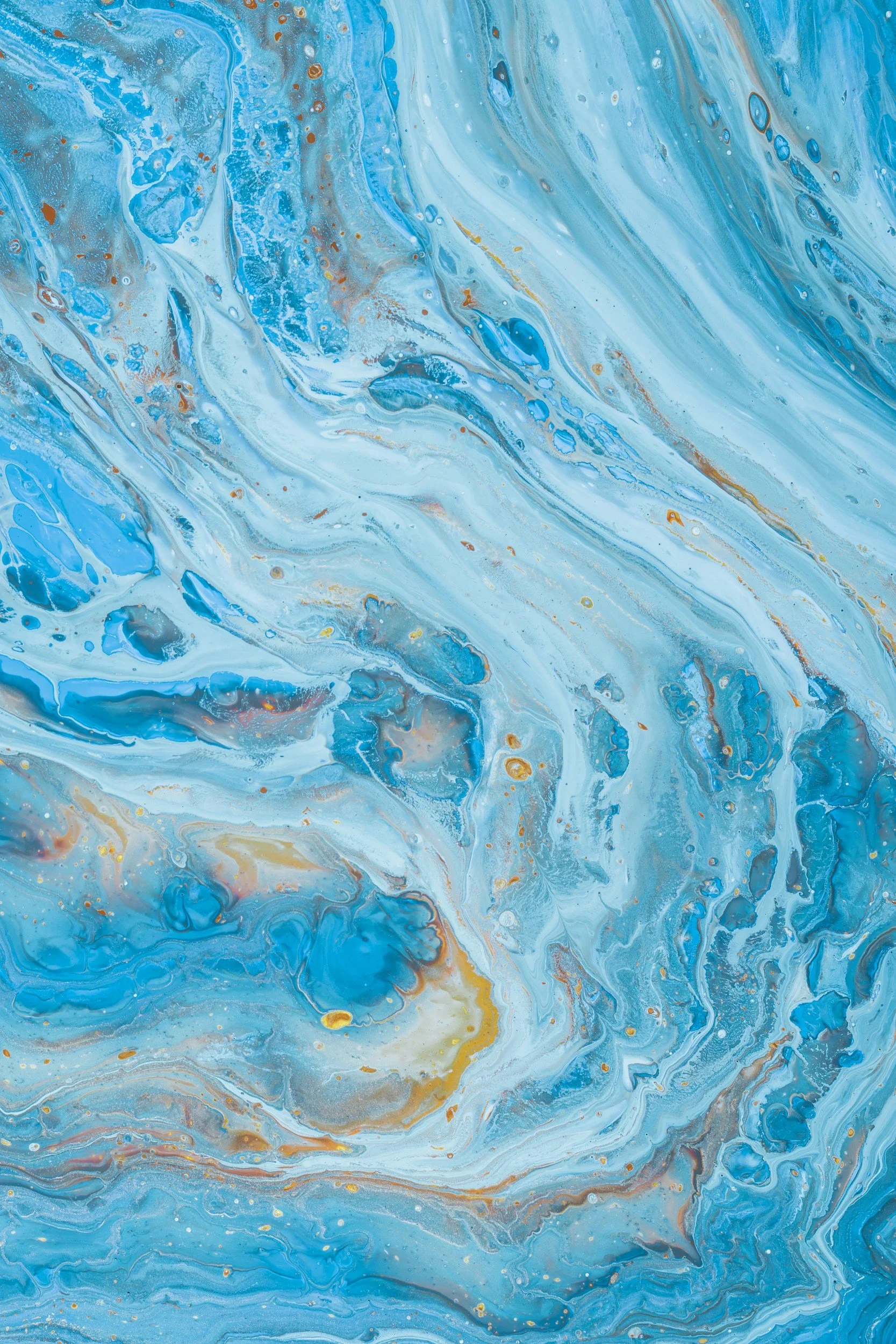 Abstract swirl of blue, white, gold, and gray colors with marbled pattern.