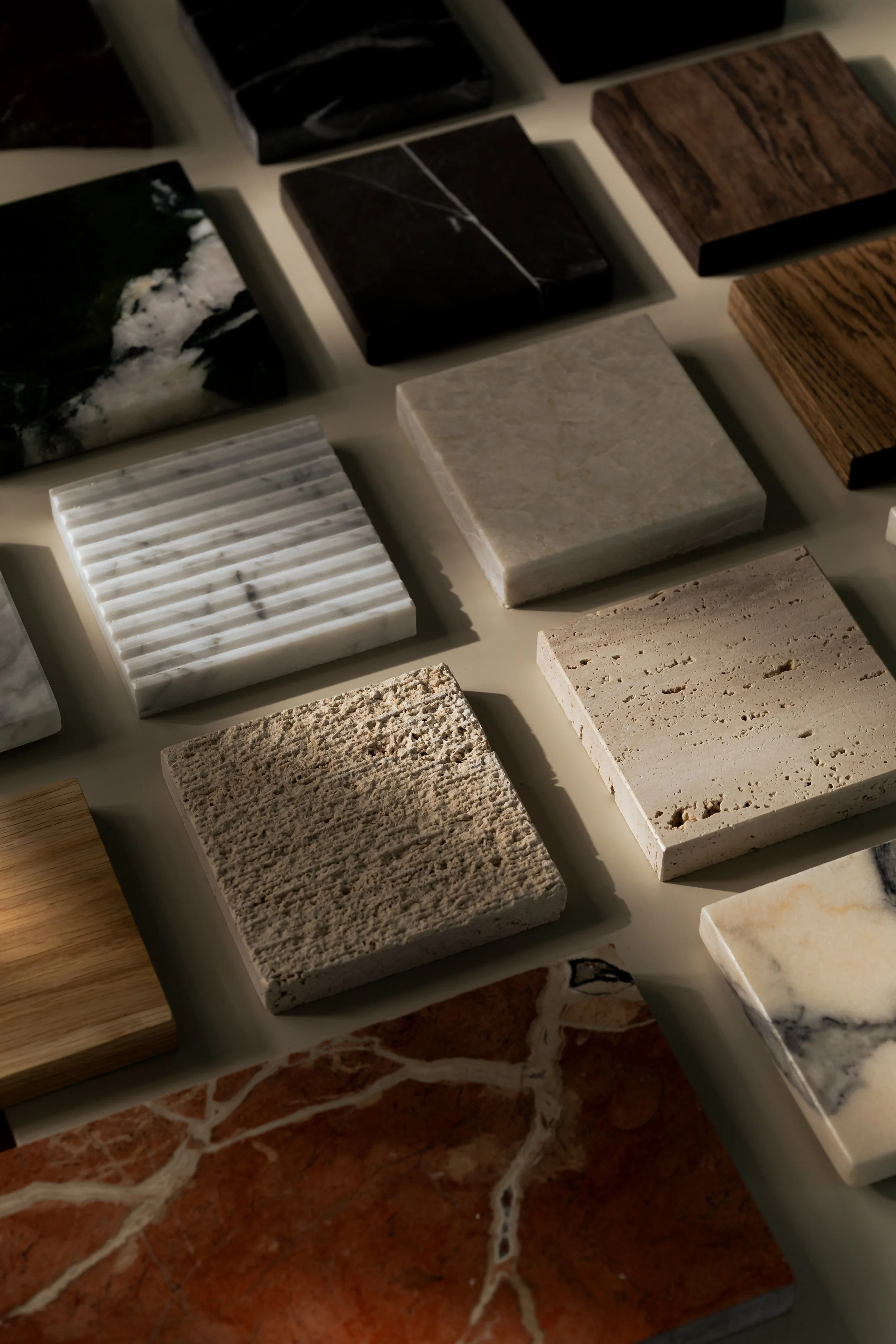 Various samples of different types of natural stone displayed on a surface.