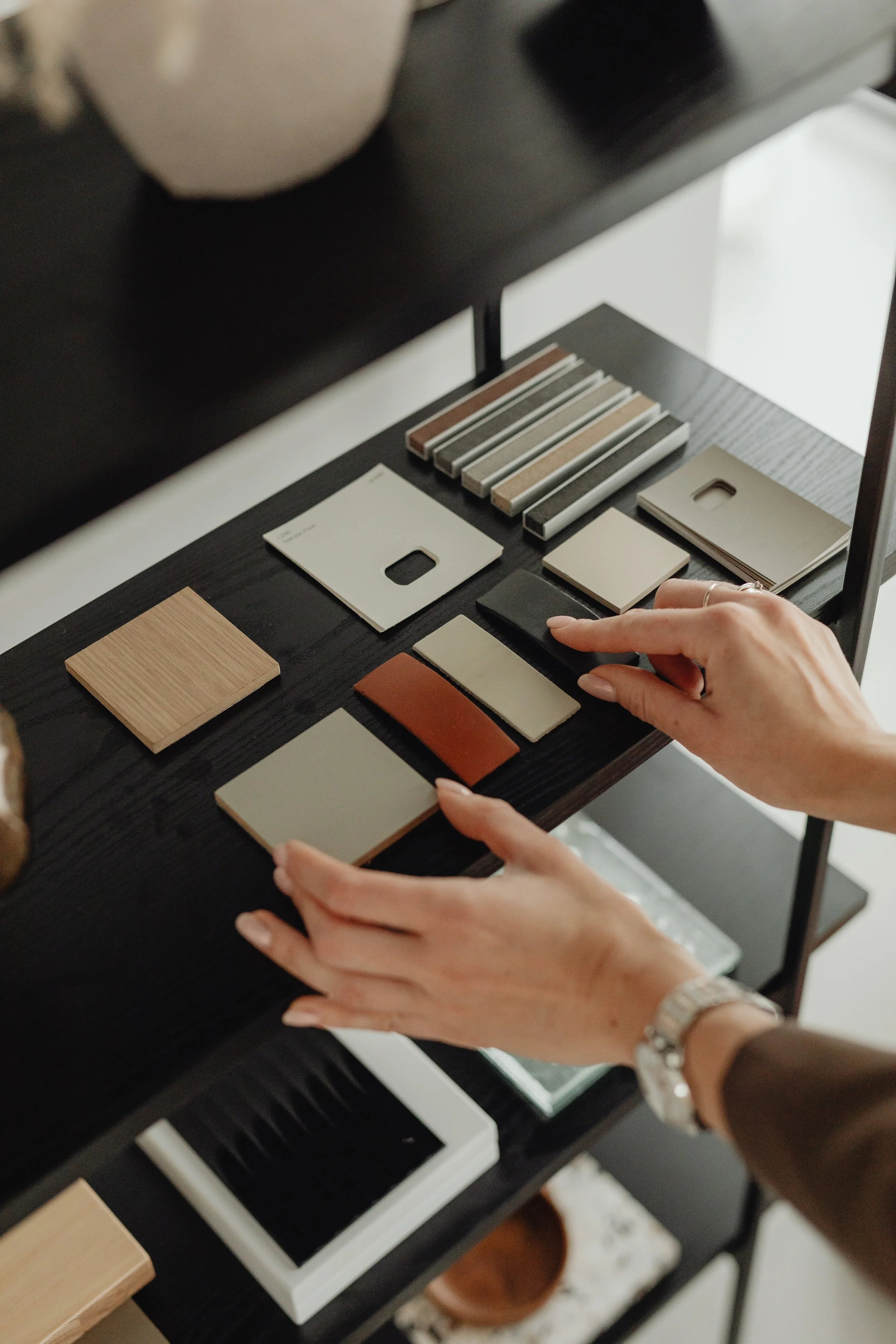 Selecting  color sample cards on a black table, with various color swatches and paint chip samples arranged in groups.