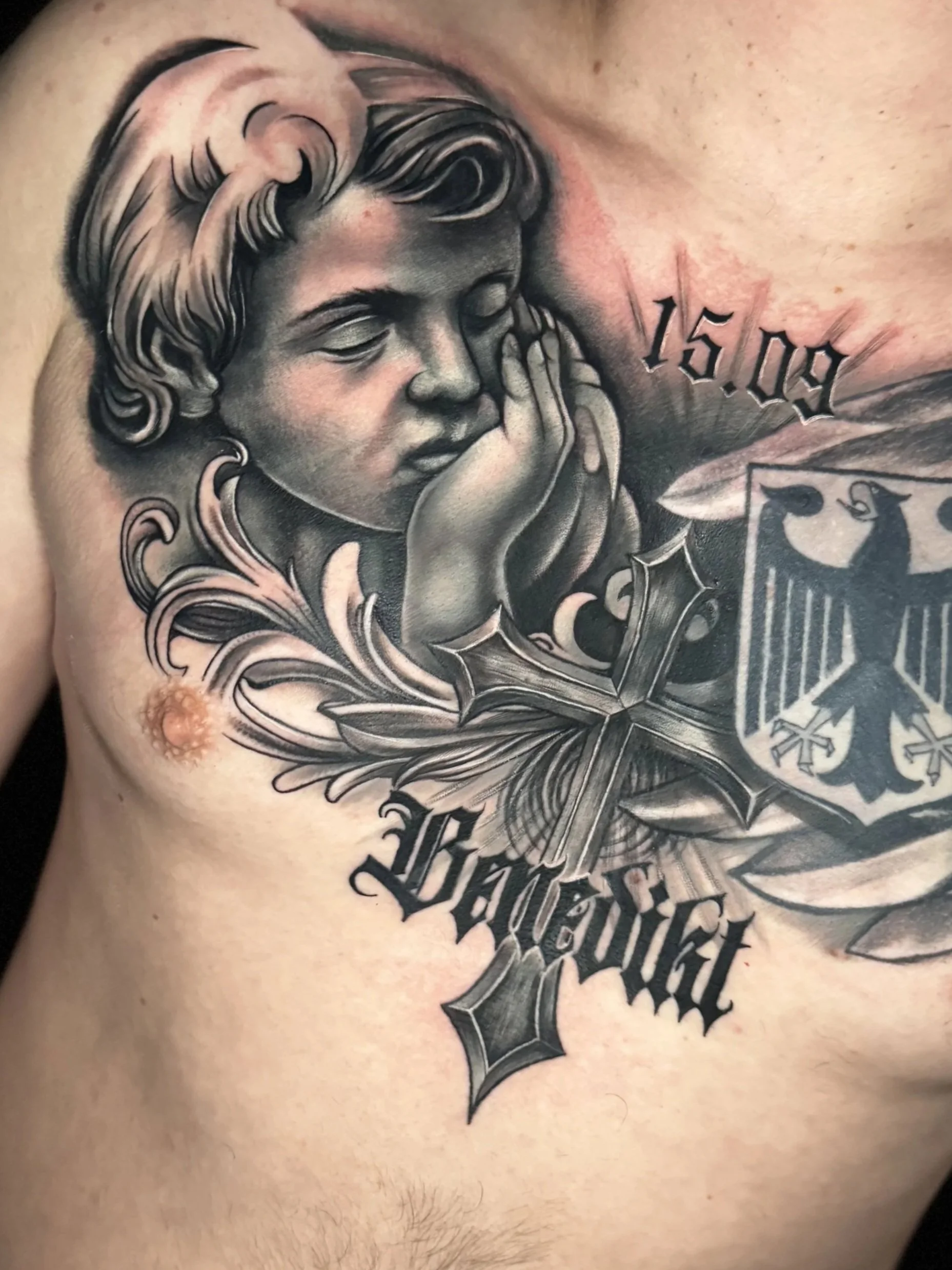 Realistische Black-and-Grey Brust-Tätowierung mit Engel, Eisernem Kreuz und Adlerwappen.