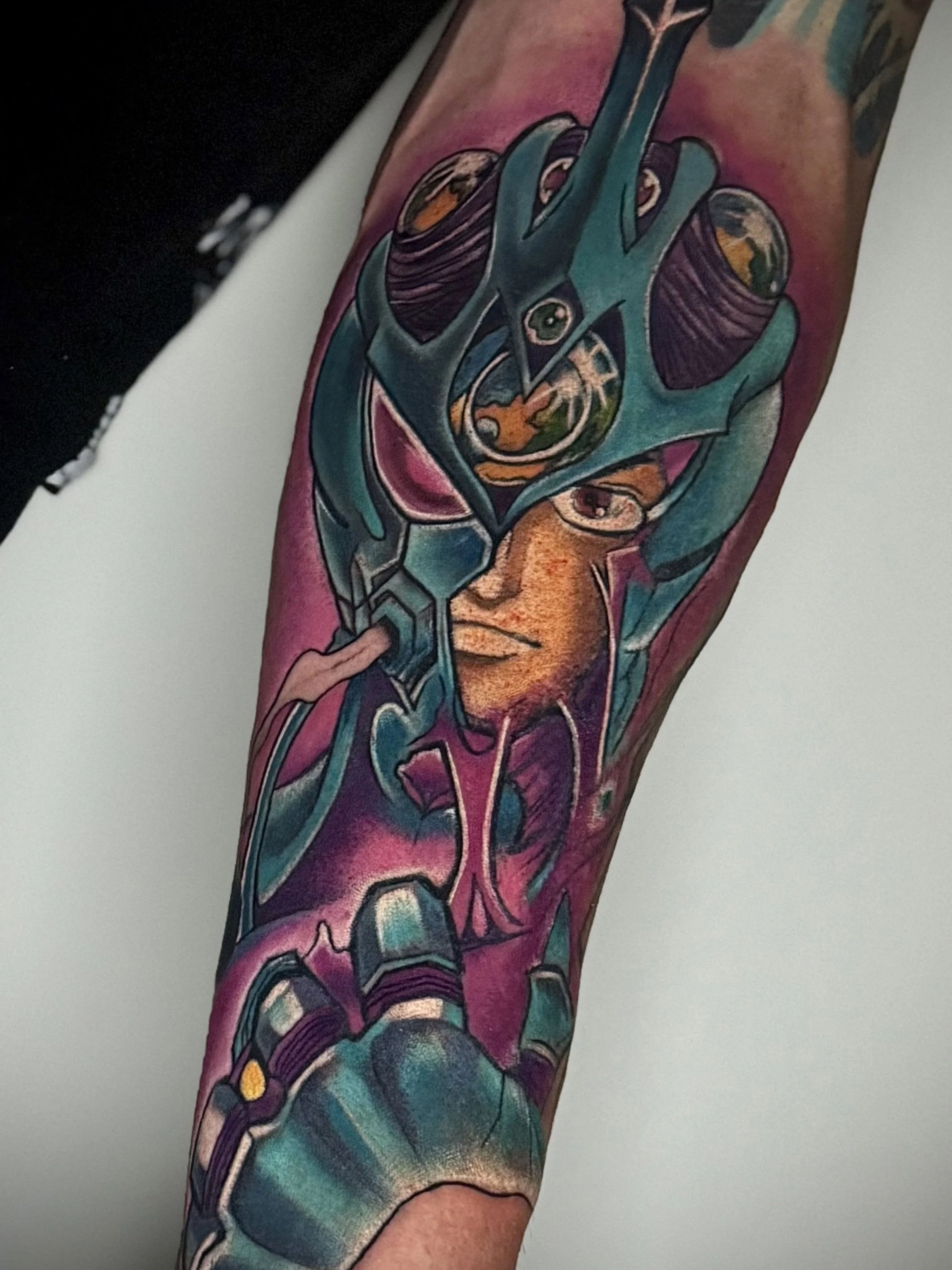 Farbige Guyver Tätowierung im Anime-Stil auf dem Unterarm. 